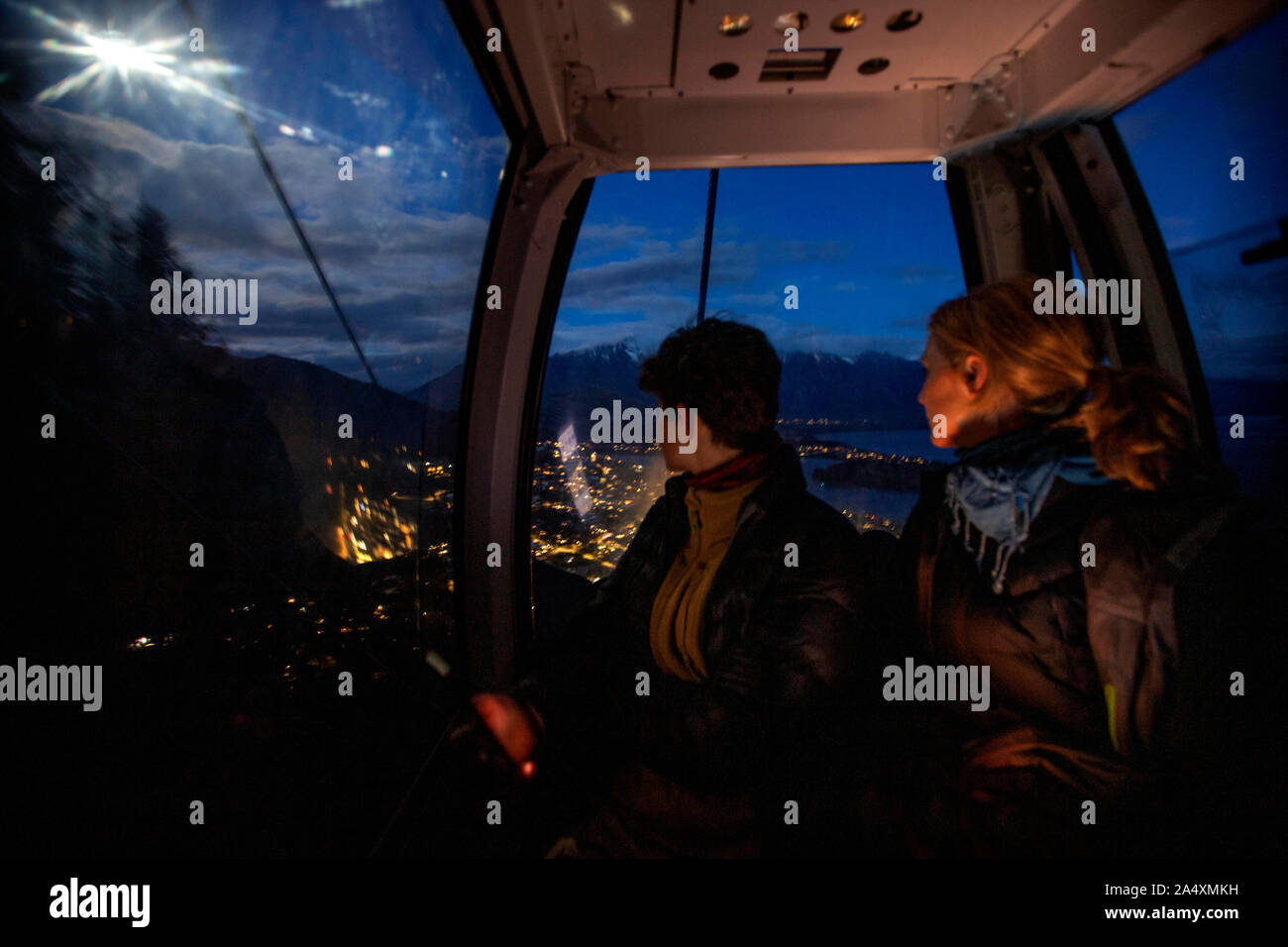 Due turisti guidare di notte in gondola a Queenstown, Nuova Zelanda Foto Stock