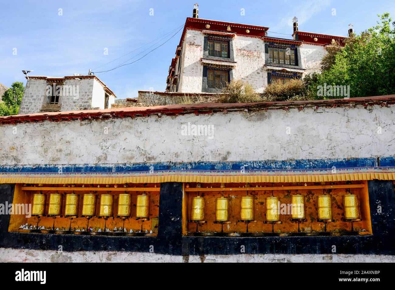 Una fila di golden ruote della preghiera adornano Deprung Monastero a Lhasa, in Tibet. Foto Stock