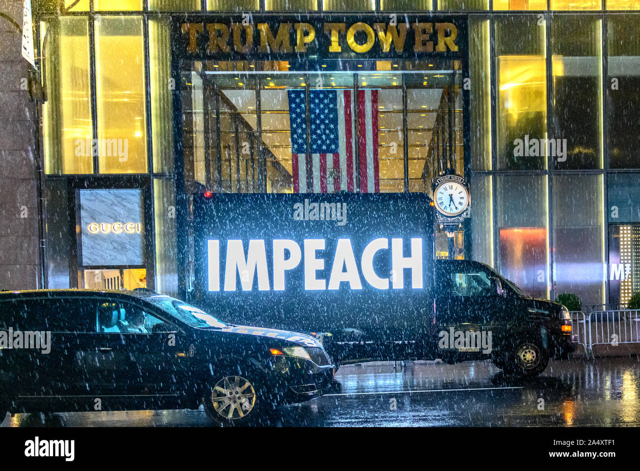 New York, Stati Uniti d'America, 16 ottobre 2019. Un carrello visualizza una grande, luminosa IMPEACH segno come si aziona attraverso New York City's Fifth Avenue di fronte al Trump Tower sotto la pioggia battente. I democratici ha iniziato una inchiesta di impeachment del presidente Donald Trump la scorsa settimana. Credito: Enrique Shore/Alamy Live News Foto Stock