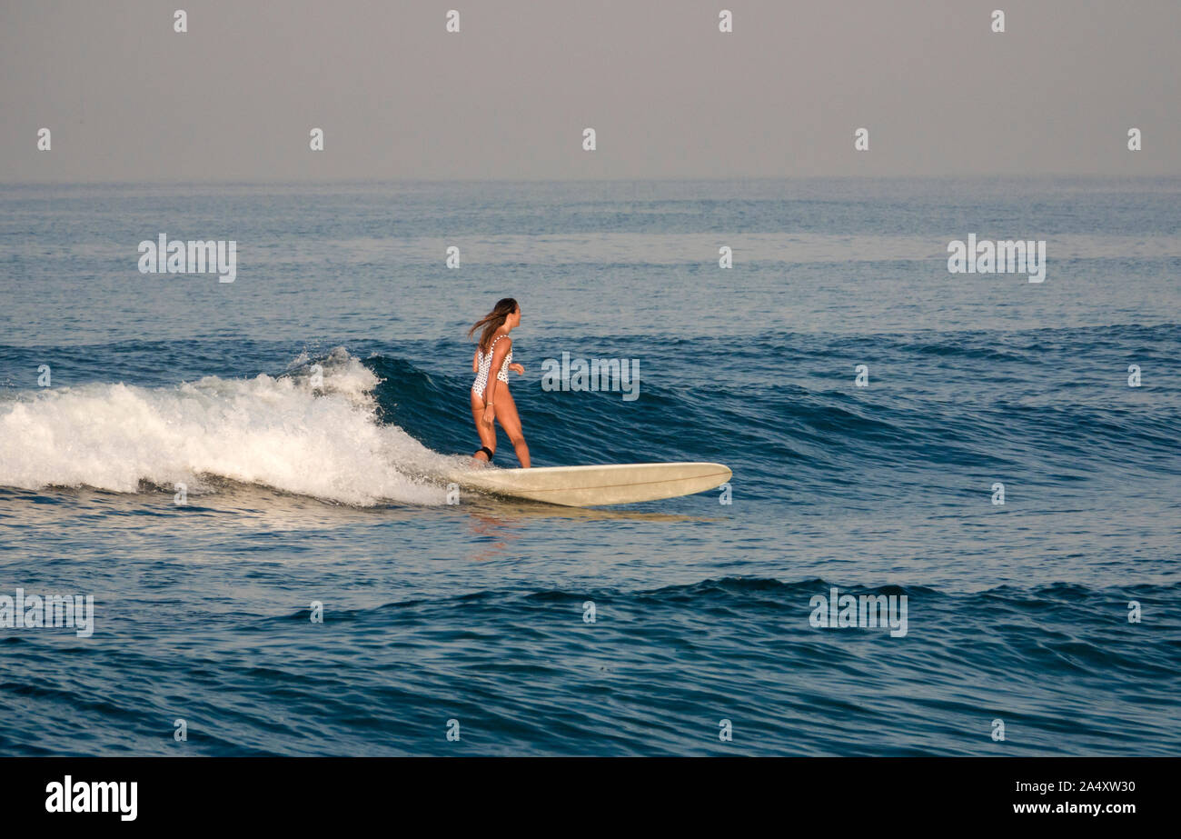 Surfista femmina wave riding in Canggu spiaggia di Bali, Indonesia Foto Stock