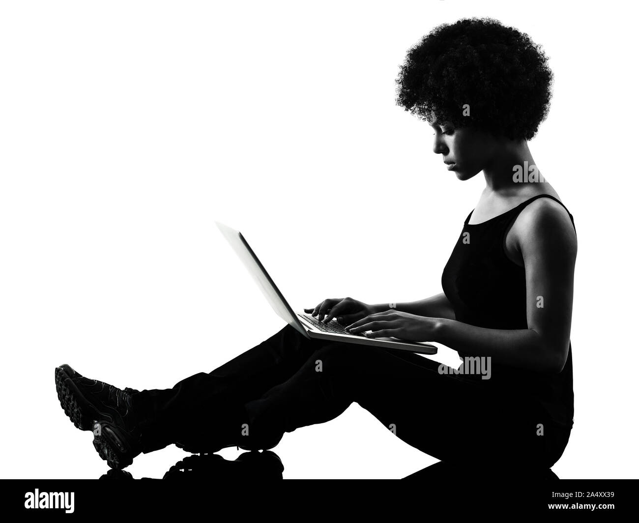 Una razza mista africana di adolescente Ragazza donna computer laptop in studio ombra silhouette isolati su sfondo bianco Foto Stock