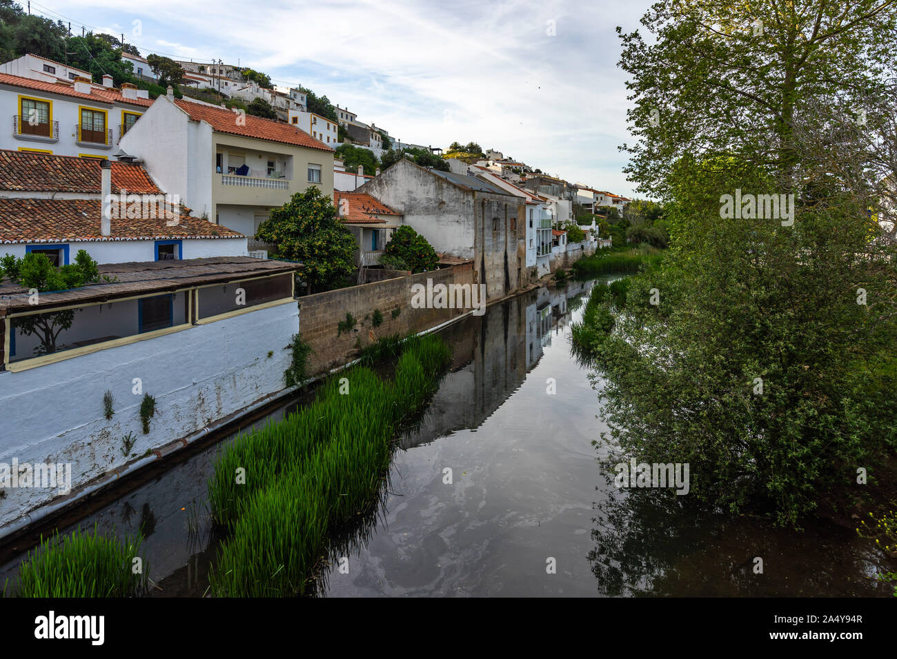 Case riflettendo in un fiume nella piccola città Aljezur, Algarve, Portogallo, Foto Stock