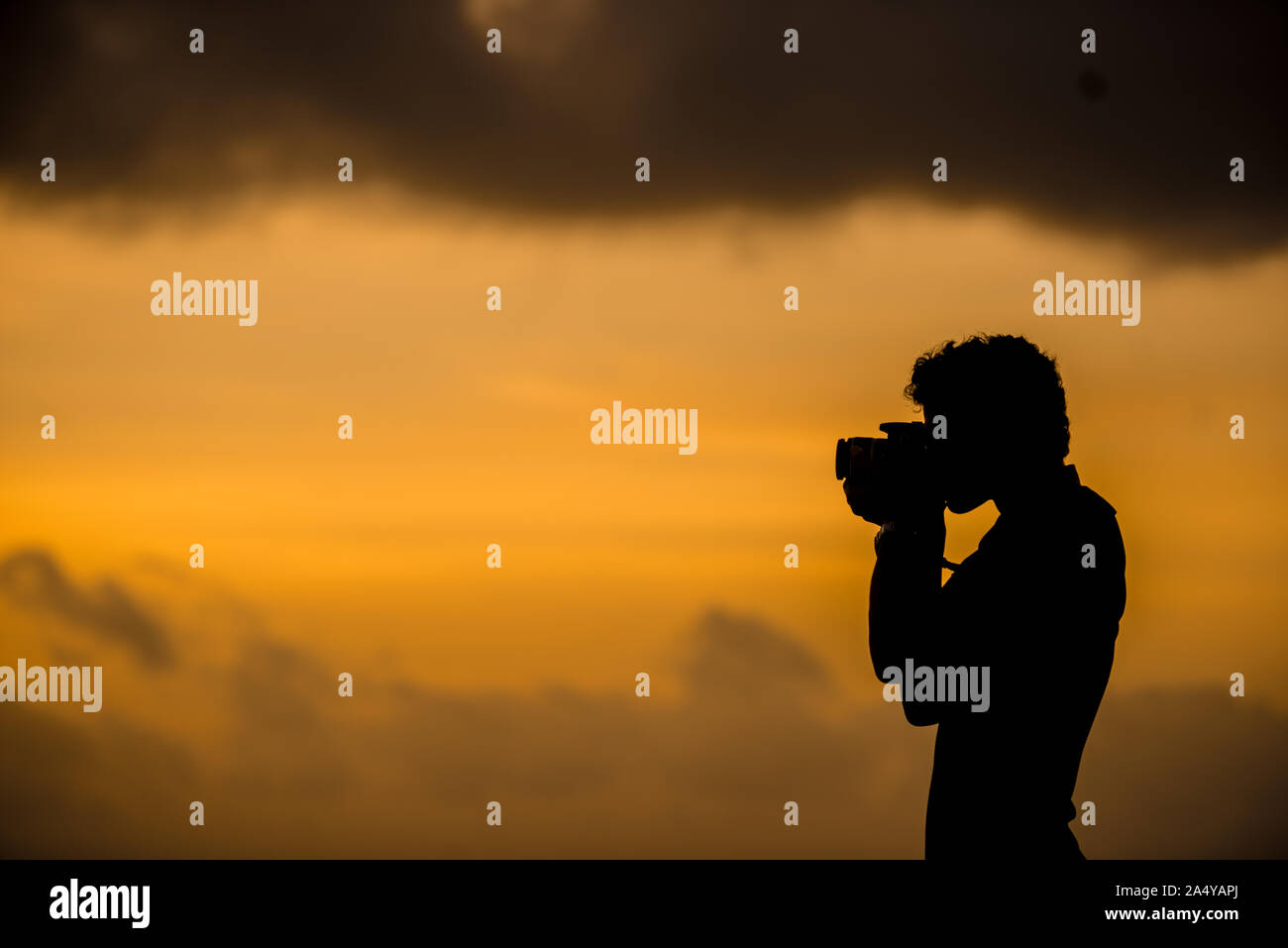 Una silhouette di un fotografo di prendere uno sunrise Foto Stock