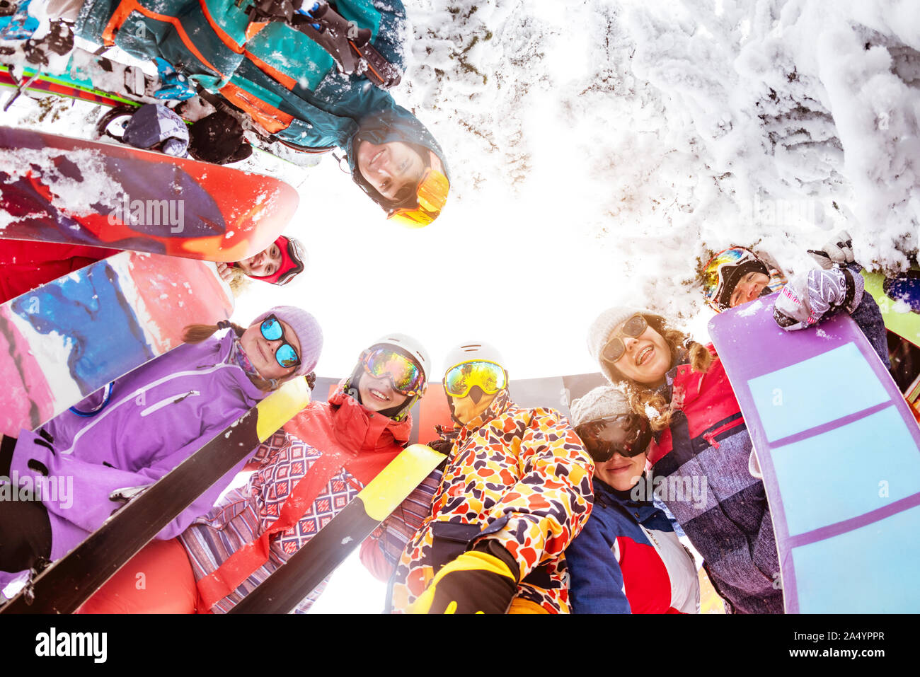Grande gruppo di amici felici gli sciatori e gli snowboarder si erge nel cerchio e guarda verso il basso. Stazione sciistica Foto Stock