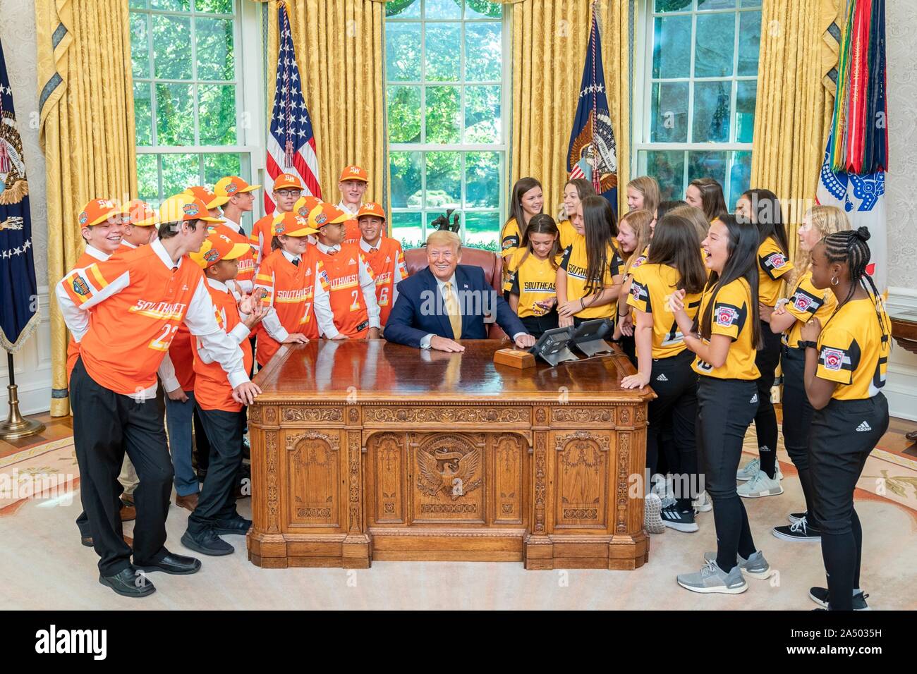 U.S presidente Donald Trump, centro, pone con membri della Little League World Series di softball e baseball champs all Ufficio Ovale della Casa Bianca Ottobre 11, 2019 a Washington, DC. Il Little League Baseball champs: la Eastbank Allstars Little League team della Louisiana, sinistra e la Rowan County Little League Softball Champs dal North Carolina, a destra. Foto Stock