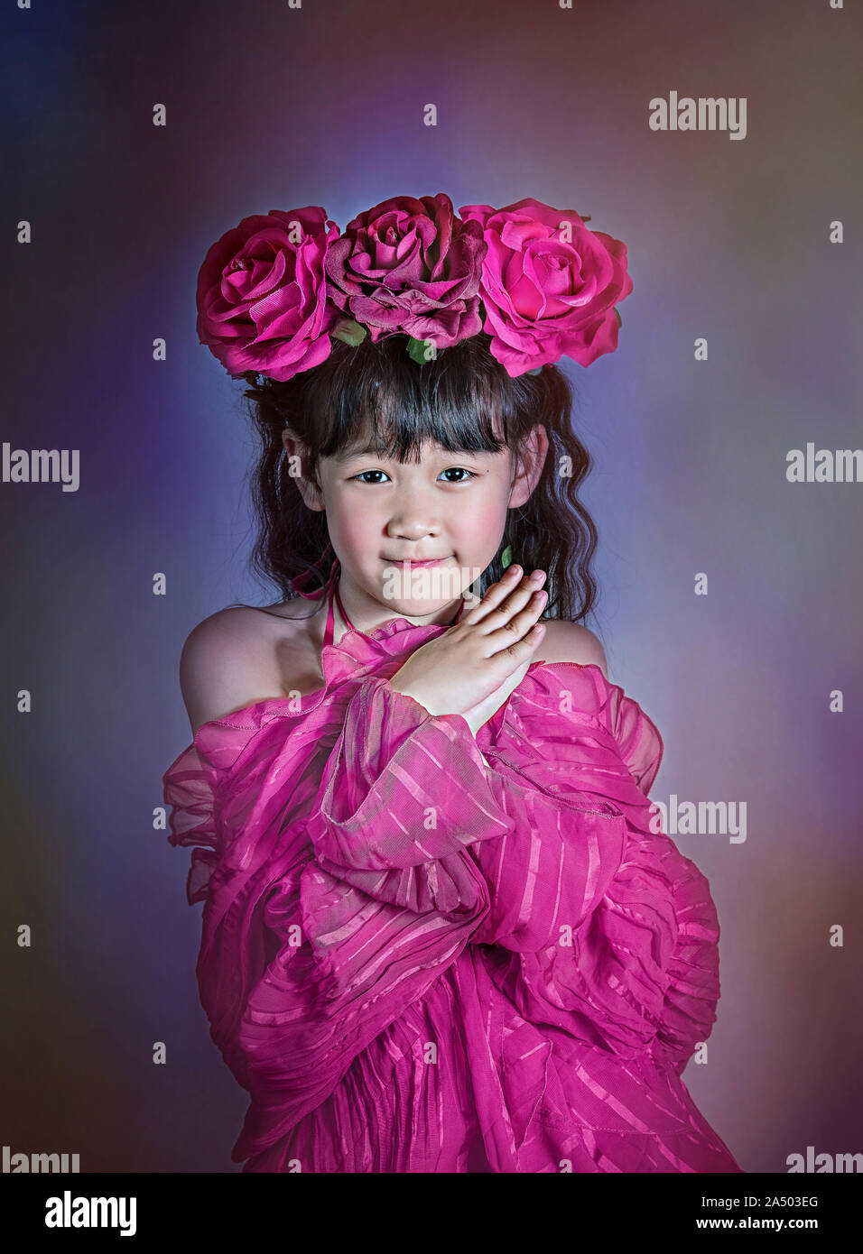 Asian piccola ragazza con i capelli neri vestito con una ghirlanda di fiori sulla sua testa Foto Stock