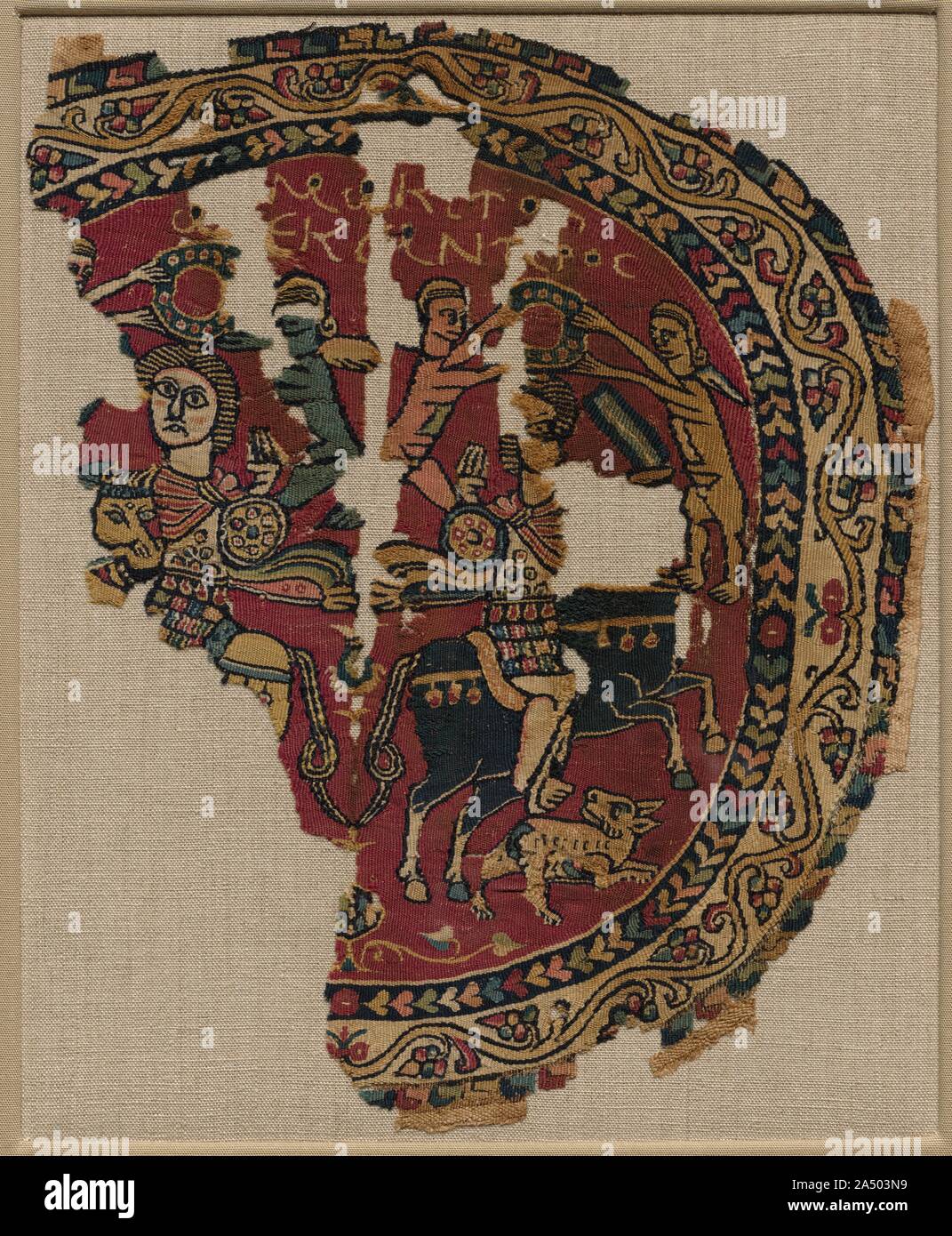 Alessandro il Grande a cavallo, 700s. Dotato di imperiale bizantina, temi di questa rara roundel decorate originalmente una tunica. Genii (custode degli spiriti) corona montato il cavaliere in abiti militari mentre un animale viene eseguito al di sotto. L iscrizione alla sommità identifica il cavaliere come Alessandro il Grande (356-323 a.C.), un culto popolare figura in Egitto per secoli. Il pattern&#x2019;s speculare simmetria indica l'influenza di più onerosa sete bizantina. Foto Stock