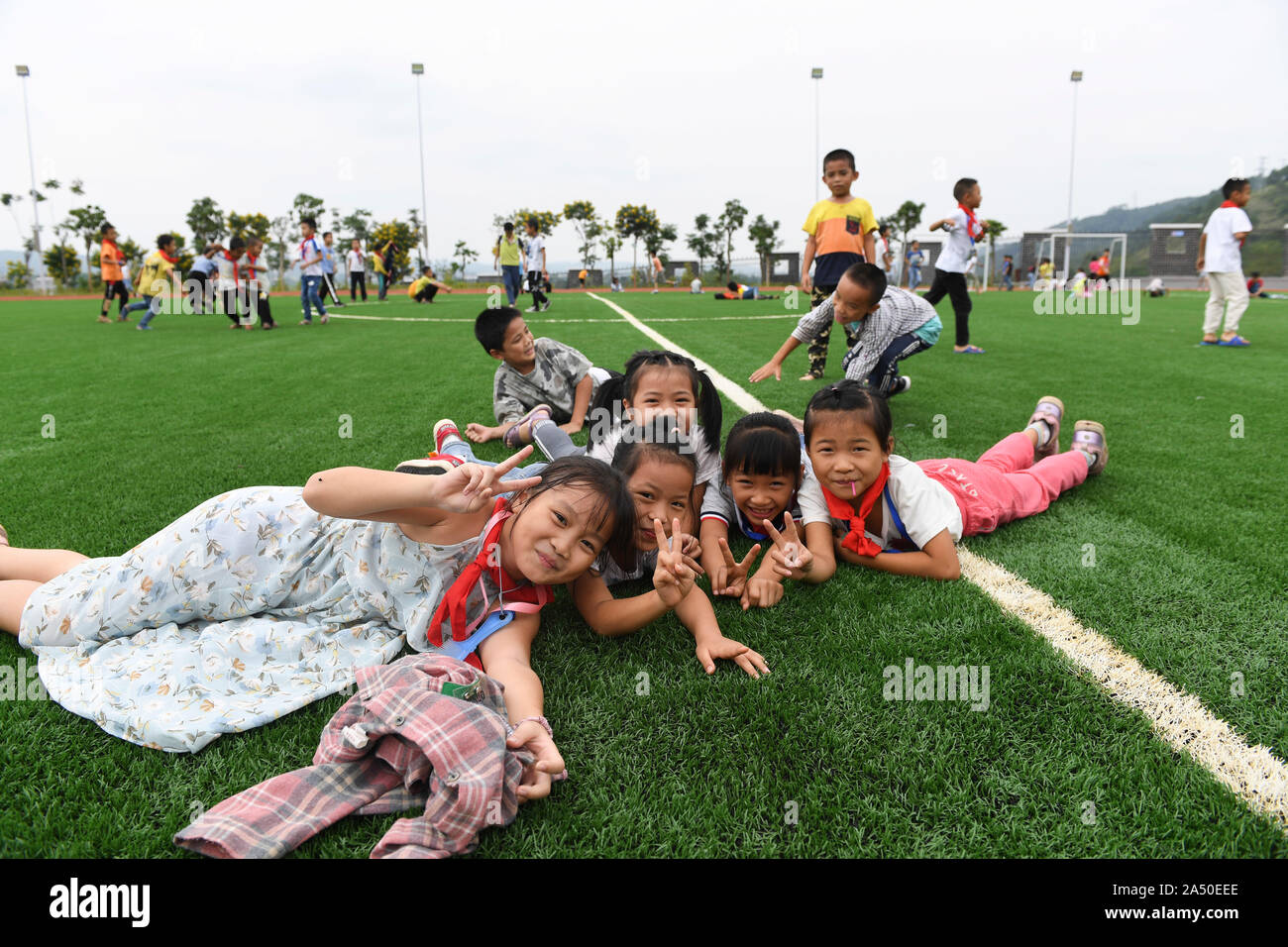 (191017) -- LONGAN, Ottobre 17, 2019 (Xinhua) -- Gli studenti giocano sul terreno della Yuegui scuola primaria in Longan County, a sud della Cina di Guangxi Zhuang Regione autonoma, 16 ottobre 2019. Yuegui scuola primaria, messi in uso nel mese di agosto del 2019, è uno dei programmi sotto un alleviamento della povertà quadro di cooperazione tra Guangxi e sud della Cina di Provincia di Guangdong. Esso è anche il progetto di supporto in corrispondenza della zona di reinsediamento per riposizionato poveri in Longan County. Ora un totale di 1.941 gli studenti a studiare presso la scuola e la maggior parte di essi vive nella zona di reinsediamento. (Xinhua/Cao Yiming) Foto Stock