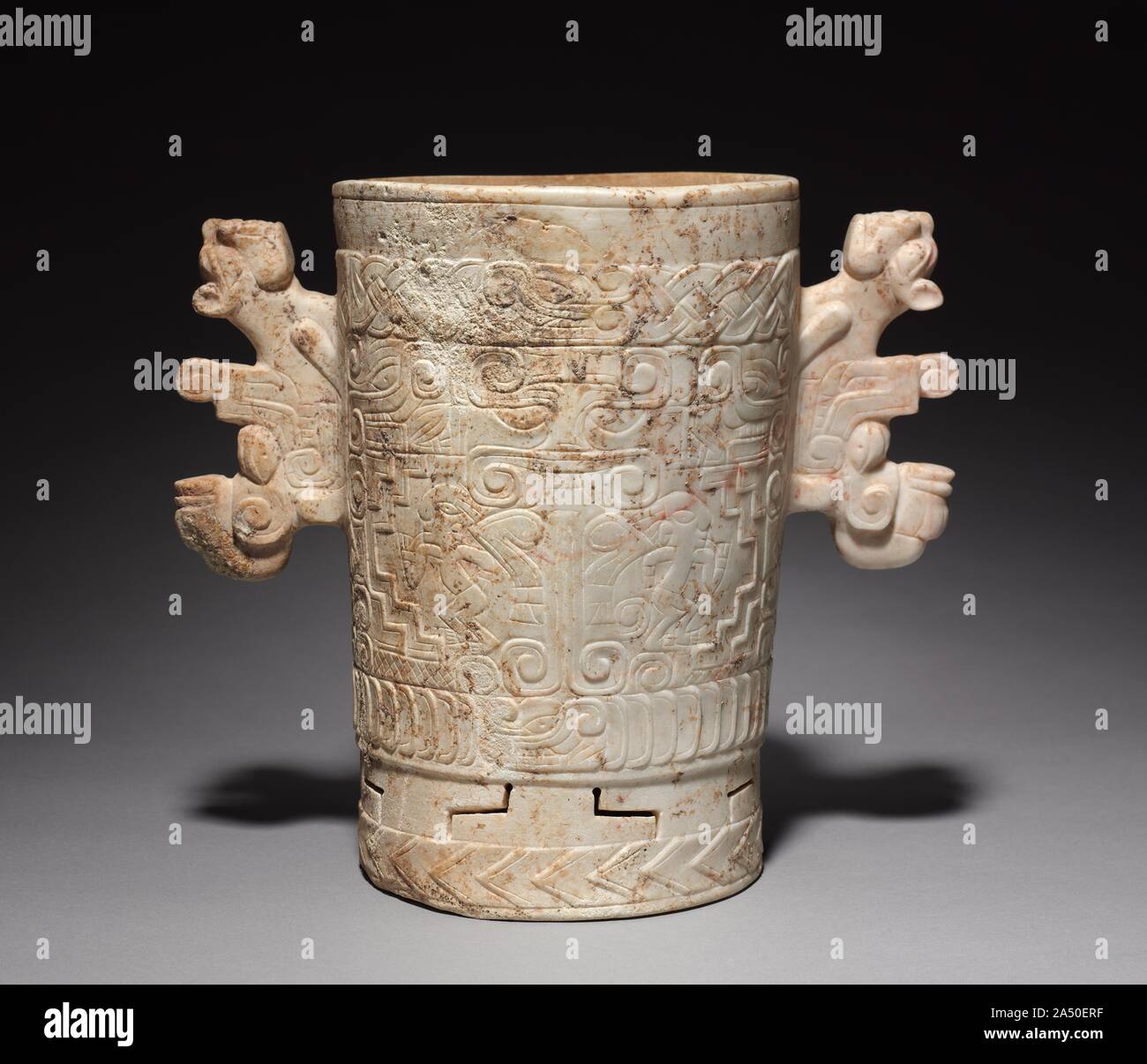 Pietra intagliata vaso, 700-1000. Questa nave di pietra, fatta dai paesi vicini orientali di Maya, è uno dei più belli e più grandi del suo genere. All'esterno sono diversi motivi che si combinano per creare un insolitamente progettazione complessa che presenta una testa grottesca, sia nel profilo o fronte con una gamba vicino alla sua imboccatura. Nel pannello principale una versione frontale della testa aleggia sulle due gambe, le ginocchia puntato bruscamente verso l'esterno. Accanto a ciascuna gamba è un vivace umana, raramente visto in tali opere. Poco è noto circa i motivi’ significati o la nave’s. Foto Stock
