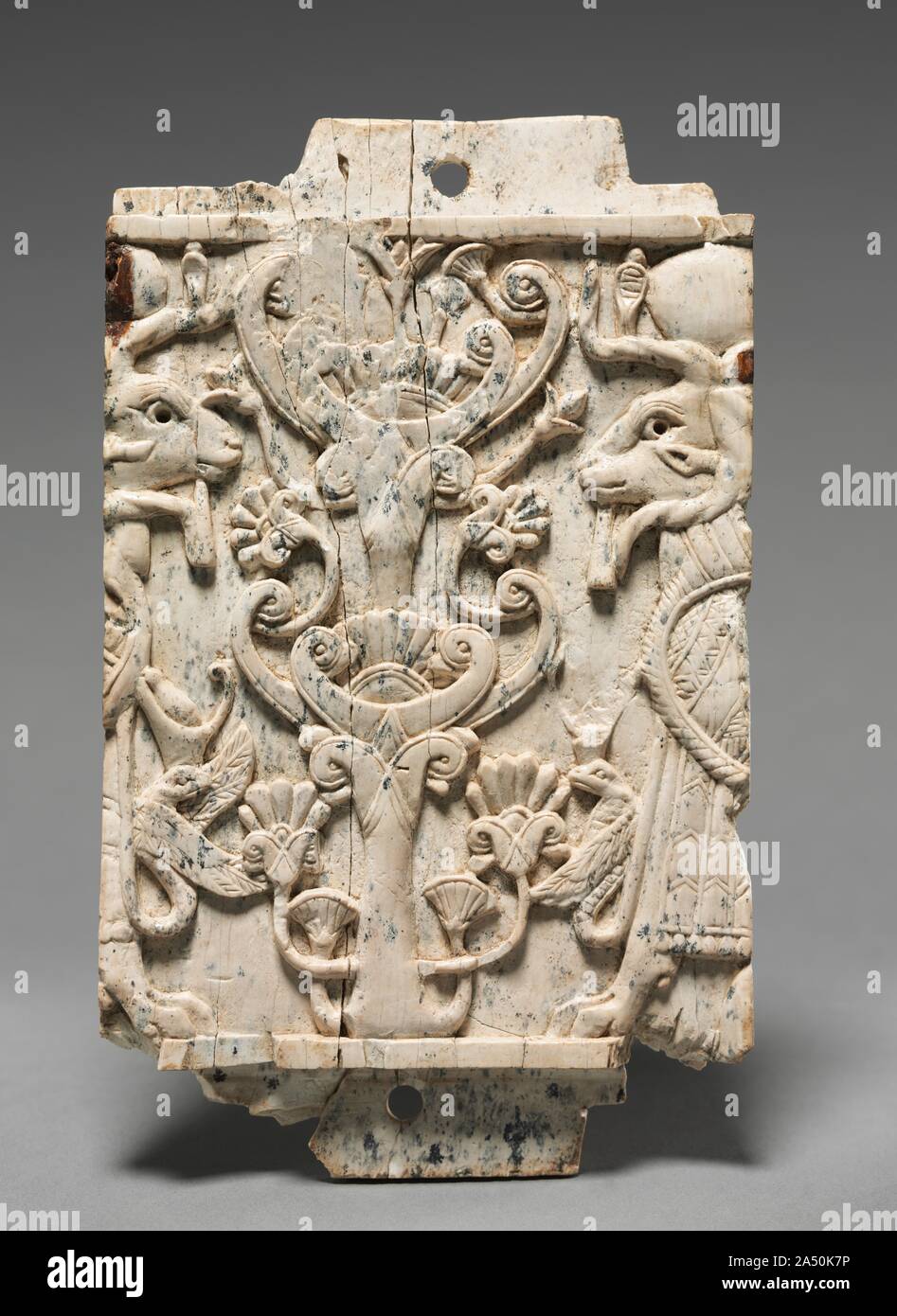 Placca decorativa: Ram-Headed sfingi fiancheggianti un albero sacro, 900-800 A.C. Questa piccola placca è stata eseguita in stile Fenicio con composizioni simmetriche allungate, proporzioni figurale e soggetti egiziano e motivi. Gli esempi sono stati trovati in tutto il Medio Oriente, ma migliaia provengono da Nimrud dove la maggior parte furono scavate nei magazzini di un arsenale militare costruito da Re Shalmaneser II (858-824 a.C.). Quando il Nimrud palace è stata saccheggiata nel VII secolo a.c. questi avori sono stati gettati in un pozzo, dove Sir Max Mallowan (il marito di Agatha Christie) scoprì nel 1951. Il Foto Stock