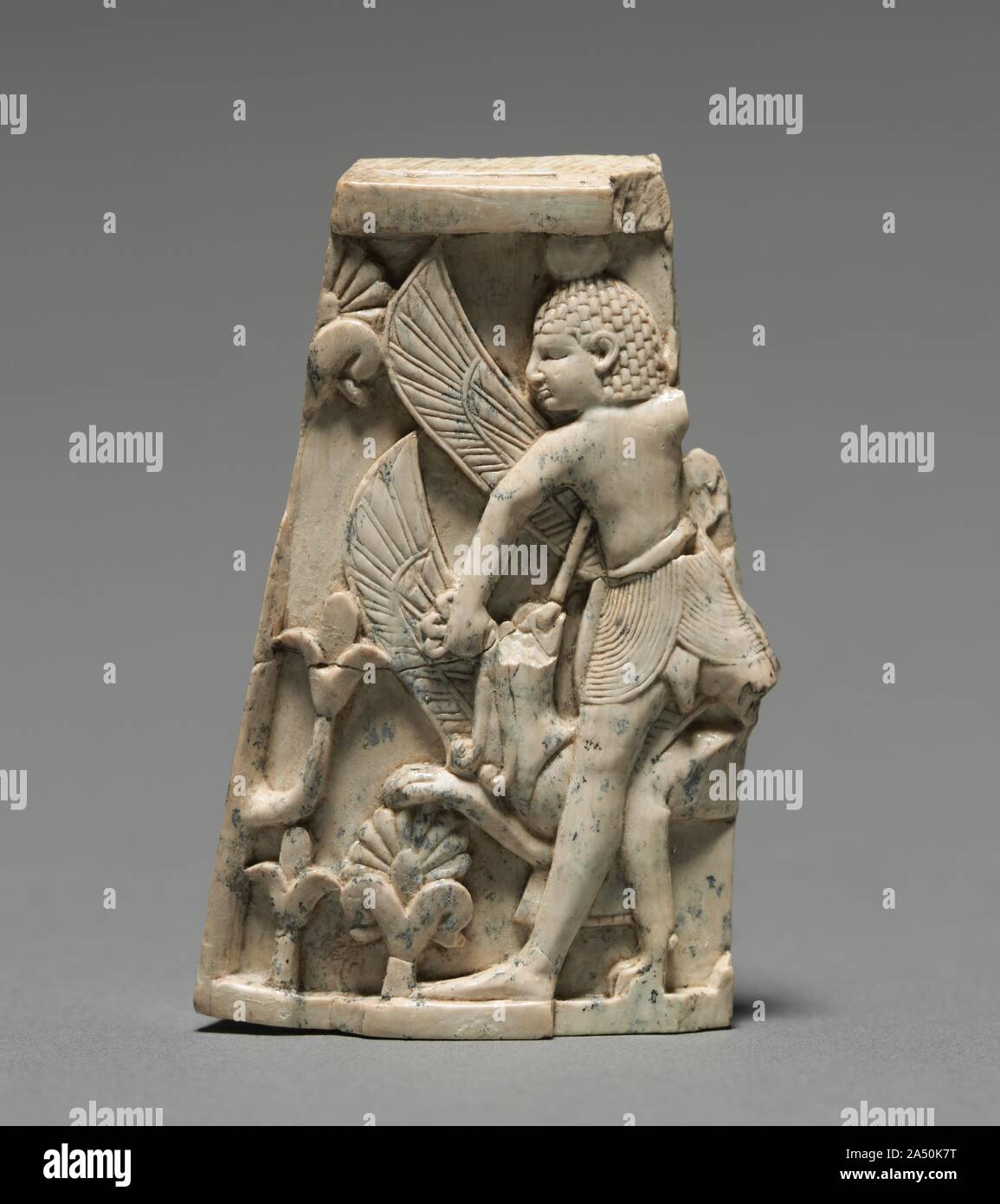Placca decorativa: l'uomo; e Griffin in combattimento, 900-800 A.C. Questa piccola placca è stata eseguita in stile Fenicio con composizioni simmetriche allungate, proporzioni figurale e soggetti egiziano e motivi. Gli esempi sono stati trovati in tutto il Medio Oriente, ma migliaia provengono da Nimrud dove la maggior parte furono scavate nei magazzini di un arsenale militare costruito da Re Shalmaneser II (858-824 a.C.). Quando il Nimrud palace è stata saccheggiata nel VII secolo a.c. questi avori sono stati gettati in un pozzo, dove Sir Max Mallowan (il marito di Agatha Christie) scoprì nel 1951. La parete monumentale Foto Stock
