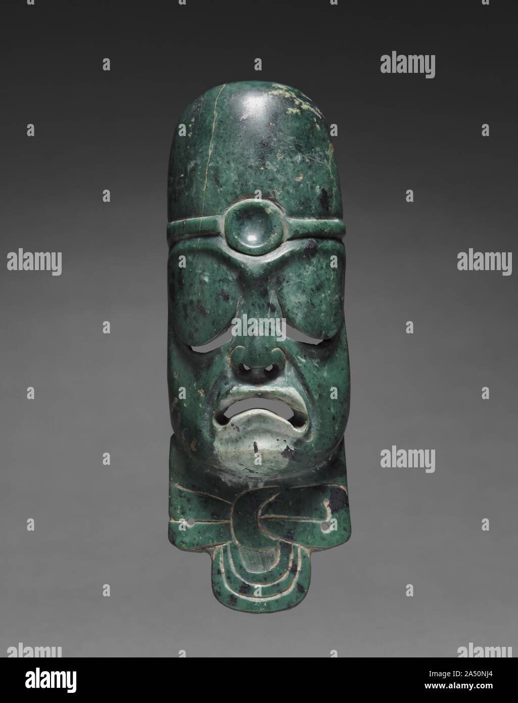 Maschera allungato ornamento, c. 900-300 A.C. Maschere di piccoli preziosi di media-specialmente greenstone, che Mesoamerican persone valutate al di sopra della maggior parte degli altri materiali probabilmente servito come elementi di Olmec elite regalia. Tali maschere comunemente raffigurano volti umani, anche se non è chiaro se la creatura mostrata in questo esempio inusuale è umano o soprannaturale. Esso può essere un fine lavoro. Foto Stock