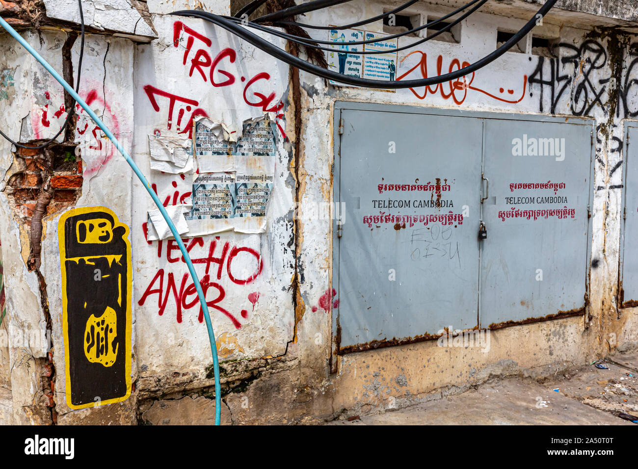 Una parete in cemento armato spray-verniciato con graffiti è adiacente ad un Telecom Cambogia decoder via cavo in Phnom Penh Cambogia. Foto Stock