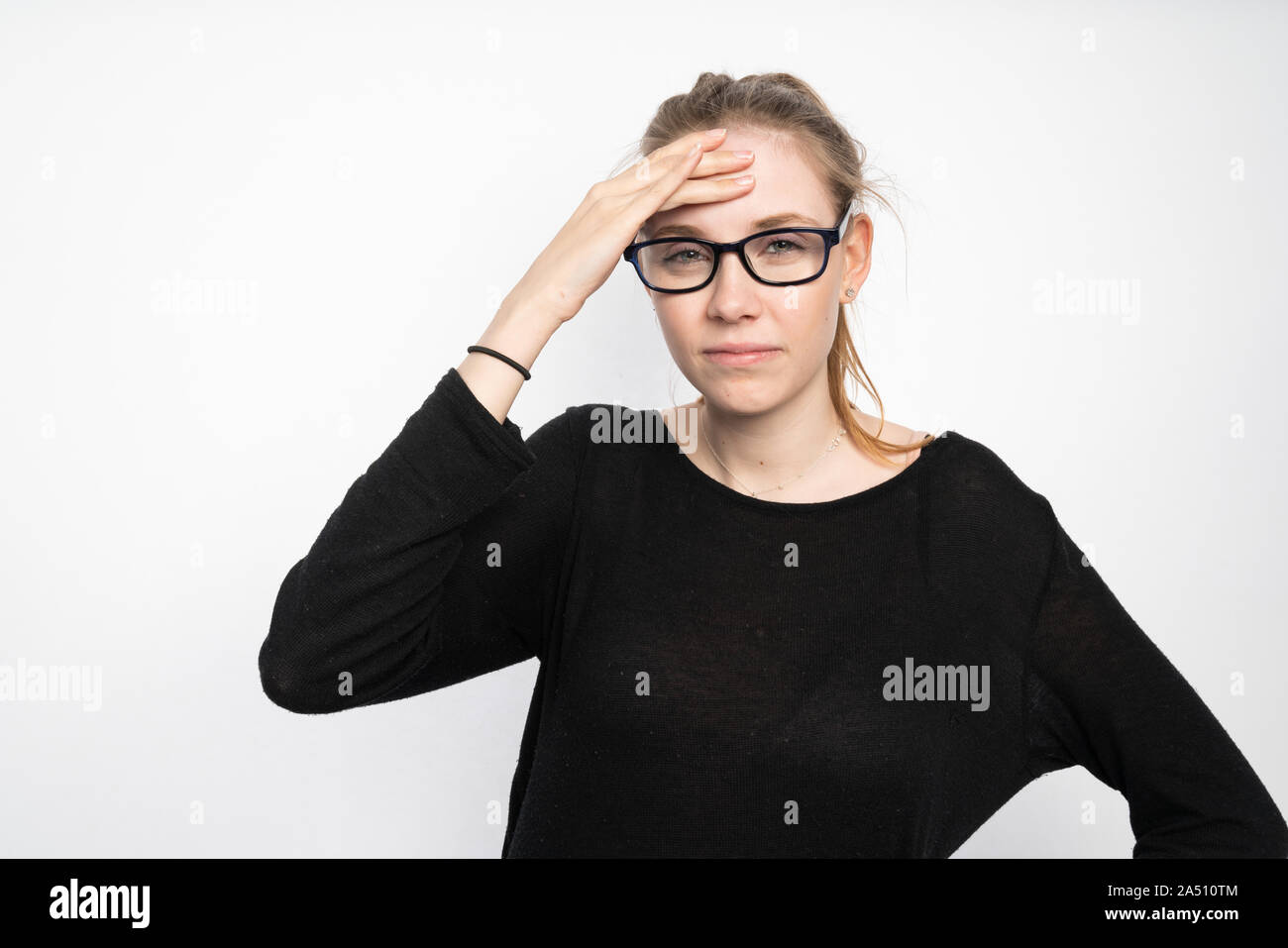 Una giovane donna mantiene la sua testa a causa del mal di testa Foto Stock