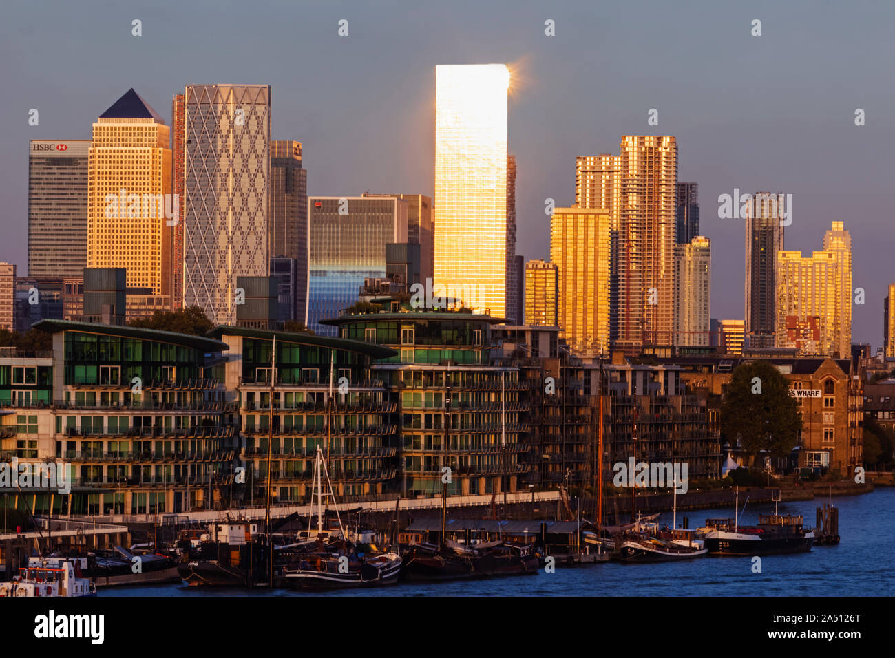 Inghilterra, Londra, Docklands, a tarda sera la luce sul Canary Wharf Skyline e il fiume Tamigi Foto Stock