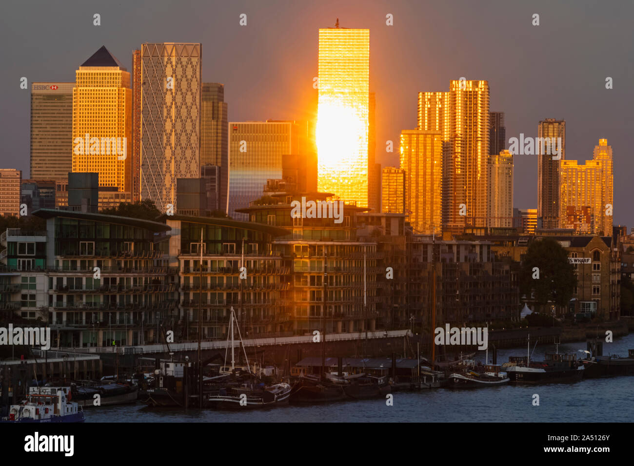 Inghilterra, Londra, Docklands, a tarda sera la luce sul Canary Wharf Skyline e il fiume Tamigi Foto Stock