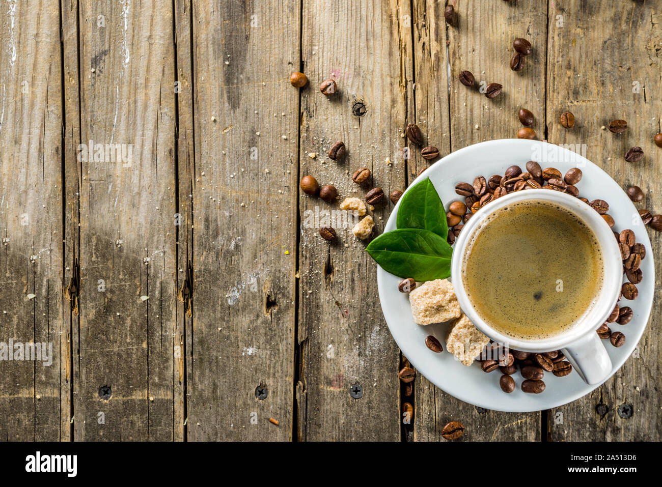 Tazza di caffè espresso con i chicchi di caffè. Il caffè macinato e foglie su sfondo rustico Foto Stock