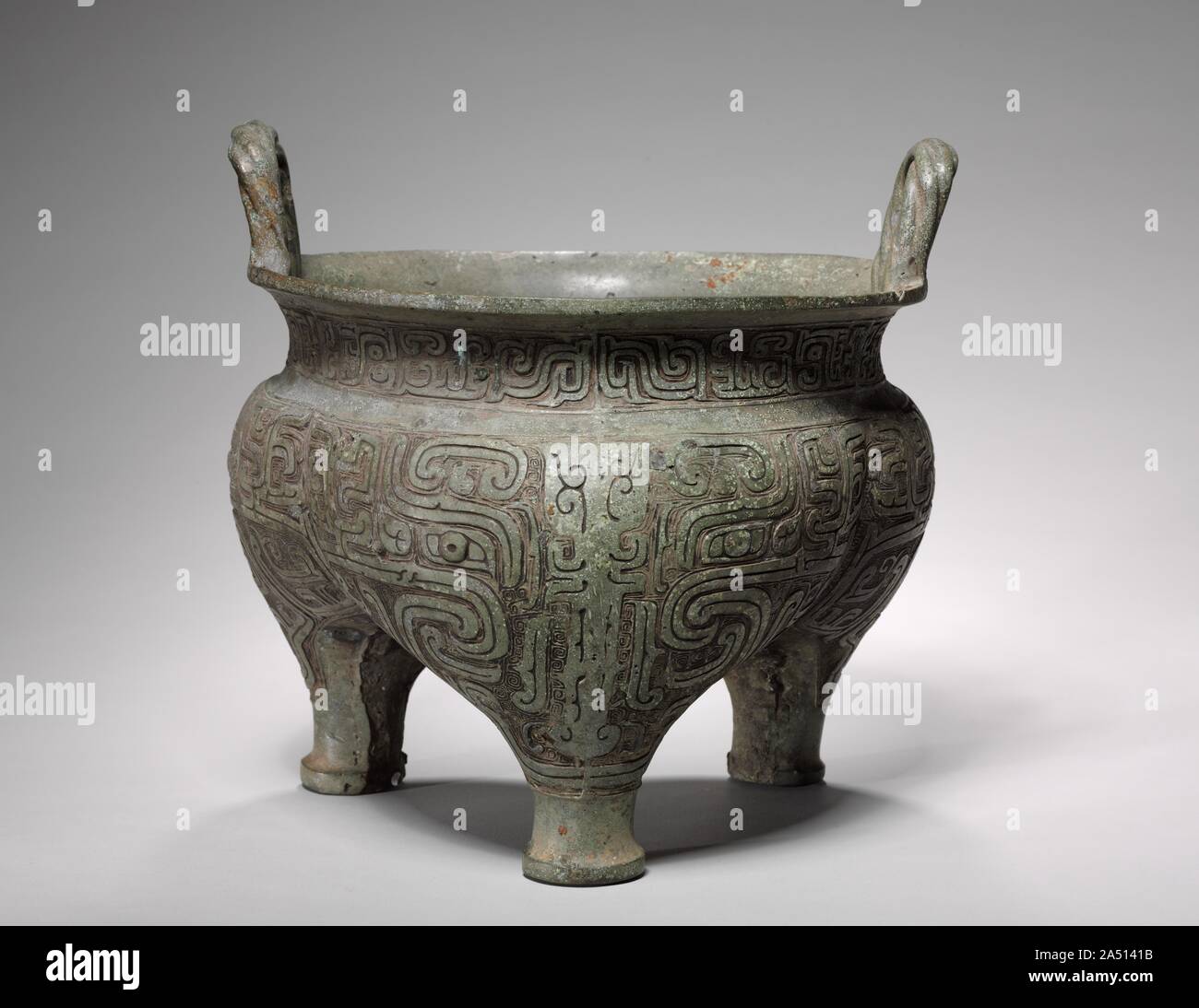 Treppiede Hollow-Legged (Li Ding), fine 900 BC. Questo recipiente di alimentare presenta una nuova tendenza decorativa del metropolitan Western Zhou fonderie. Immagini zoomorfe divenne sempre più astratta e oggetto di elaborazione lineare. La dominante maschera animale (taotie) del Shang è qui trasformato, sciolti e dissezionato in modelli intricati delle bande di curvatura e scanalature mediane. Il design è astratta ma non priva di contenuti simbolici e le funzioni. Una superficie liscia e anche grigio patina verde--il risultato della corrosione naturale durante la sepoltura--copre l'esterno e crea un nuovo impatto visivo sulla superficie deco Foto Stock