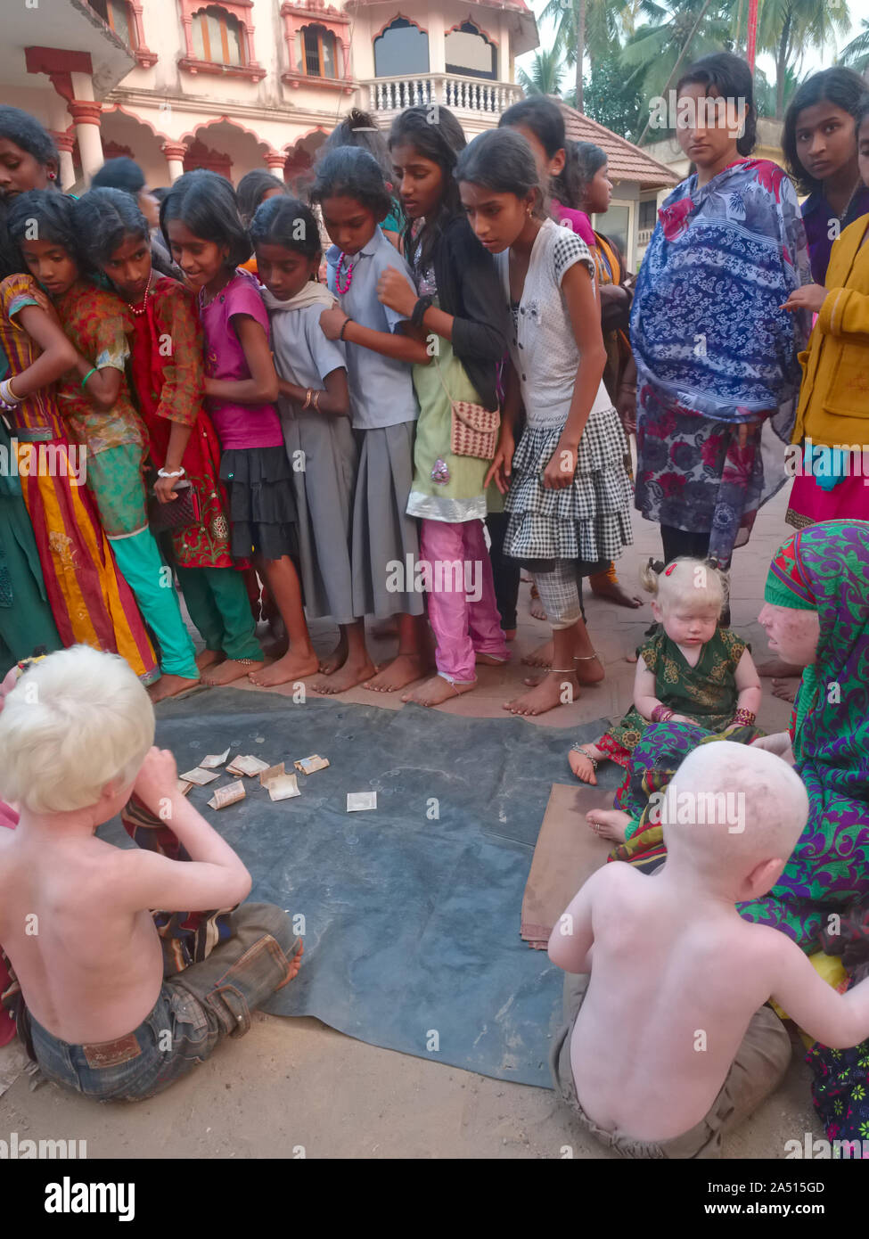 I bimbi albini, di membri di un indiano estesa famiglia Albini, richiedono donazioni in Udipi, Karnataka, India, fissò da una folla di bambini locali Foto Stock