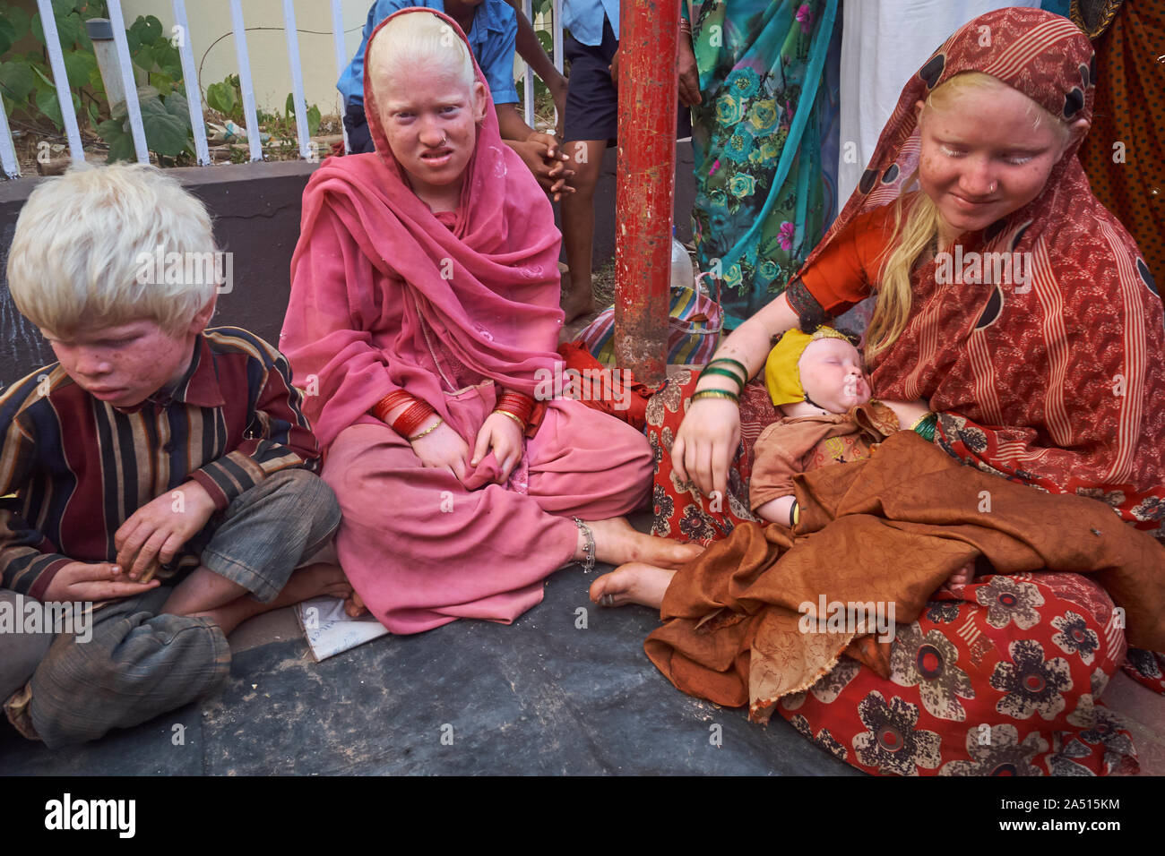 I membri di un indiano famiglia Albini, due donne e due bambini, richiedono donazioni in Udipi, Karnataka, India, circondato da gente del posto Foto Stock