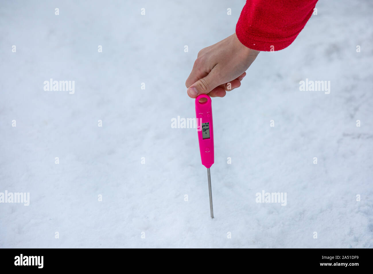 Uomo di tenere in mano un termometro per misurare la temperatura del manto di neve Foto Stock