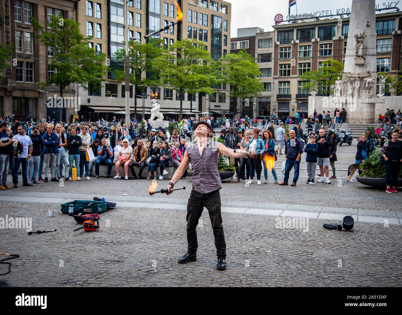 animatore di strada che giocolano bastoni brucianti intrattenere una grande folla, Piazza Dam, Amsterdam, Olanda. Foto Stock