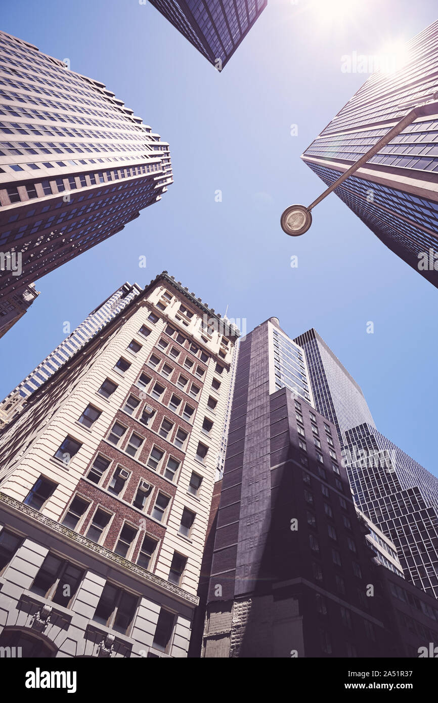 Cerca fino a New York grattacieli contro il sole con lens flare, dai toni di colore immagine, STATI UNITI D'AMERICA. Foto Stock