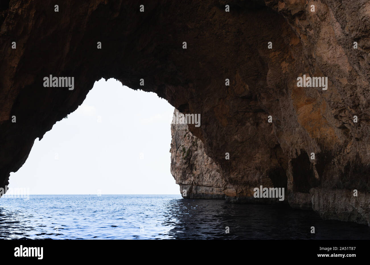 Paesaggio panoramico, vuoto oscura grotta di roccia costiere. Blue Grotto, Malta Foto Stock