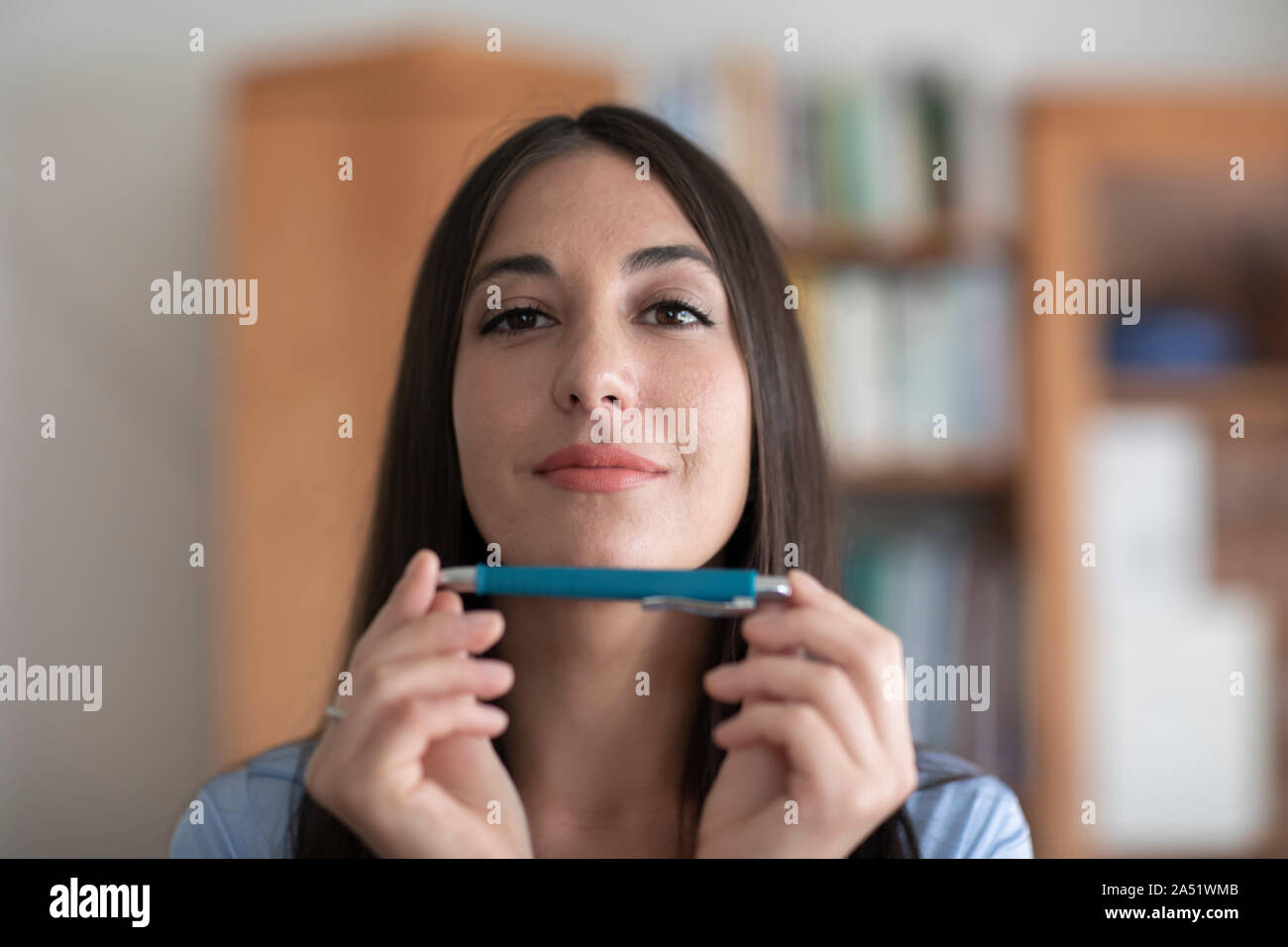Studente giovane donna di apprendimento con una matita nelle mani Foto Stock