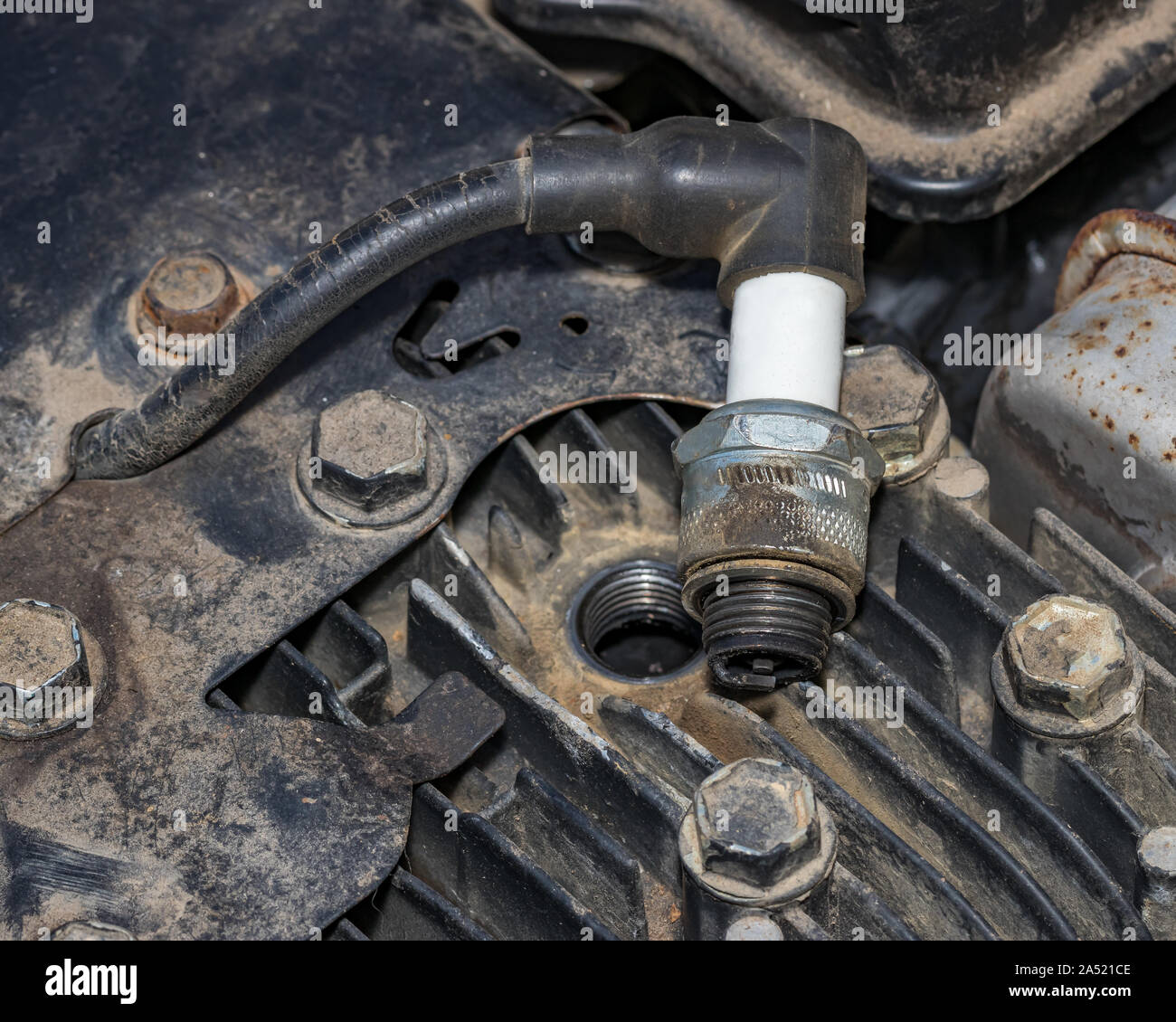 Primo piano della candela di accensione rimossa dal piccolo motore a gas sui tosaerba. Concetto di home procedura dyi manutenzione, messa a punto e la riparazione Foto Stock