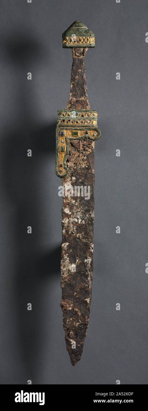 Coltello Single-Edged (Scramasax), c. 500-700. La scramasax, un singolo coltello tagliente, è stato un obiettivo generale dell'attrezzo. Essa potrebbe servire ugualmente bene come uno strumento o come un arma e di solito non può superare i dodici pollici in lunghezza. Come con la maggior parte degli oggetti del periodo di migrazione, armi di ferro sopravvivere come tomba scavata merci e tendono ad essere notevolmente corroso. Le impugnature, oggi mancante, erano probabilmente ricavato da legno o osso e argento decorato a intarsio i capitelli a vaso (la manopola sull'elsa, o maniglia). Il ornamentali in lamina d'oro bande, forse dall'originale scabbards (i casi in cui le lame di spade o pugnali Foto Stock