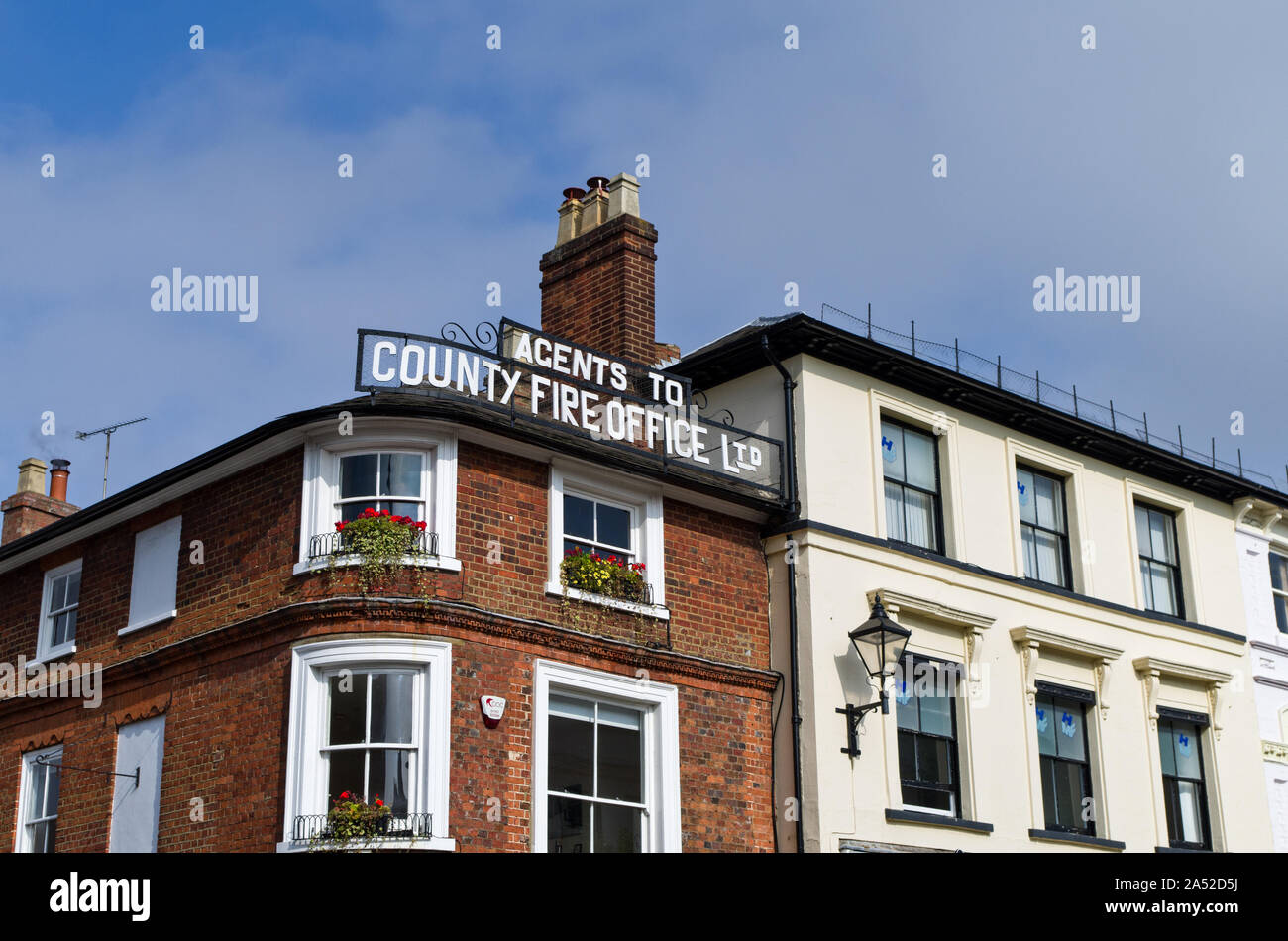 Il vecchio segno di metallo per "agenti di contea fuoco Office Ltd" sulla linea del tetto di un edificio nel centro della città, Ampthill, Bedfordshire, Regno Unito Foto Stock