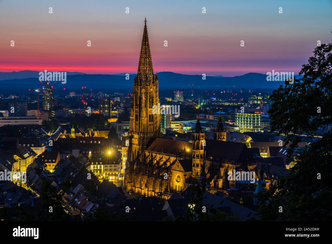 Germania, romantico rosso tramonto Cielo sopra bellissima foresta nera città Friburgo in Breisgau a Baden con la famosa cattedrale gotica chiamato minster dal di sopra Foto Stock