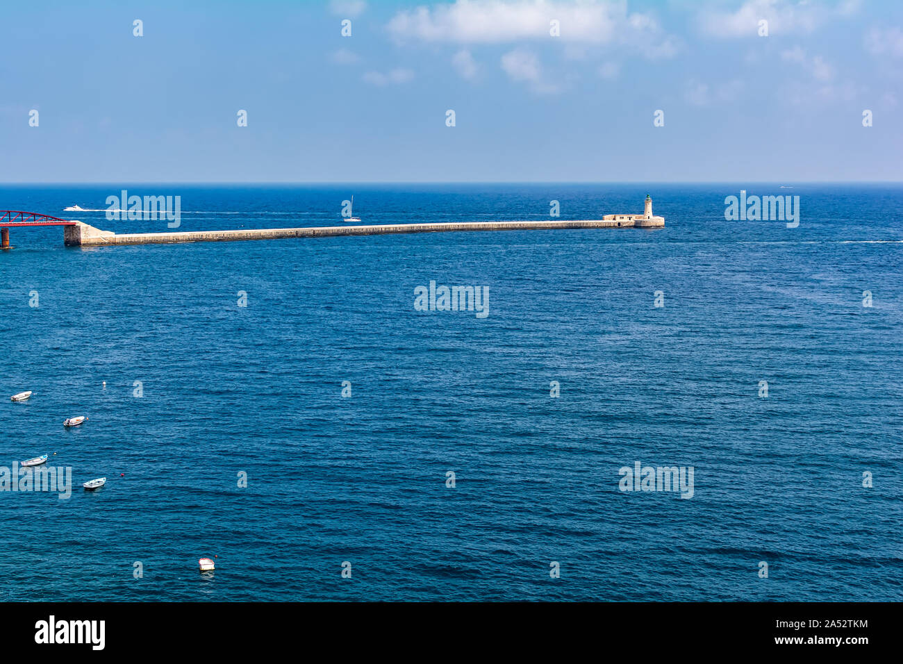 La Valletta frangiflutti e del faro (noto anche come San Elmo testa frangiflutti luce) all'ingresso del Grand Harbour con parte di St Elmo Bridge. Foto Stock