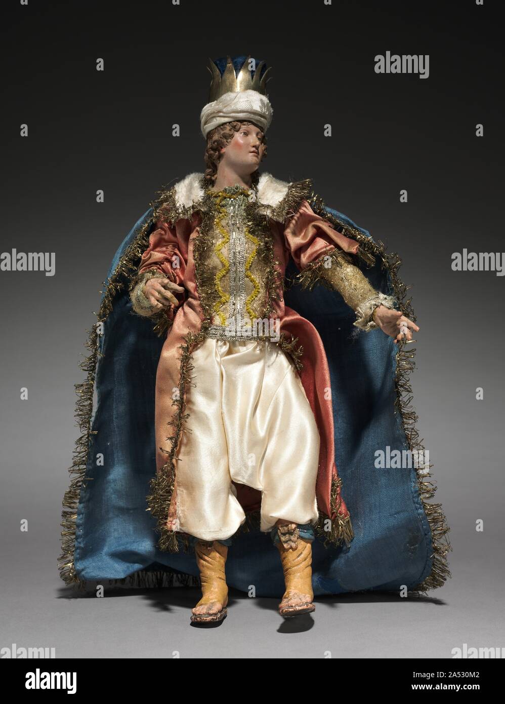 La figura da un Cr&#xe8;che: giovane mago, 1780-1830. La pratica della creazione di scene della natività per la casa risale agli inizi del Settecento in Italia, dove la gente ha cominciato a impostare la bambola-come figure di circa un piede o meno in altezza. La consuetudine è stata particolarmente popolare a Napoli intorno al 1800, dove cr&#xe8;che scene (cr&#xe8;che significa culla o lettino) incluso molte figure, le cui teste e mani di terracotta dipinta, ripieni di corpi di stoffa e vestiti adattati dalla contemporanea costumi locali ha dato loro un incredibilmente realistico carattere. Rappresentazioni della nascita di Gesù può essere ricondotto alla Foto Stock