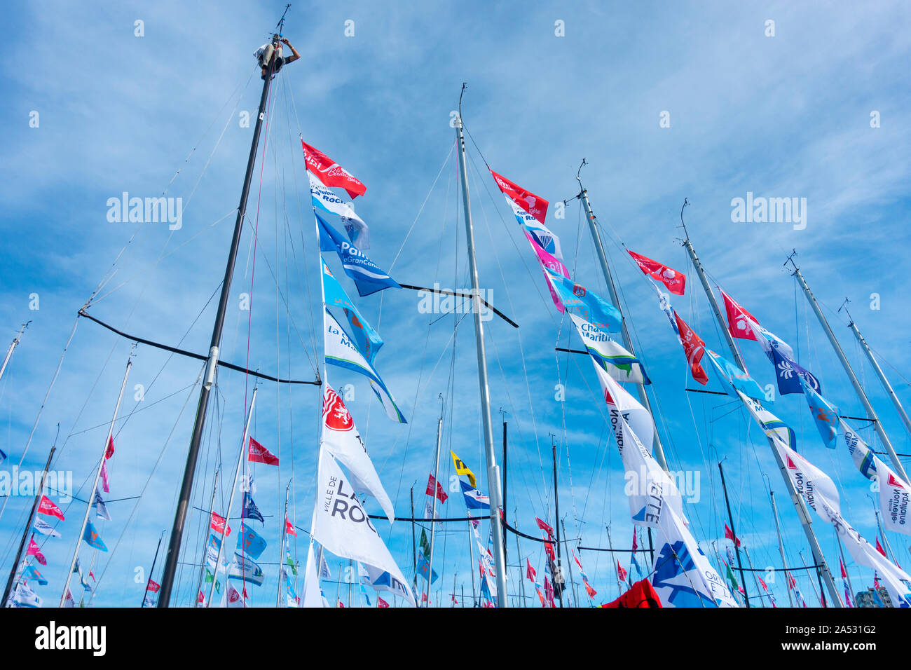 A Las Palmas di Gran Canaria Isole Canarie Spagna.17 Ottobre, 2019. Un marinaio si arrampica il montante come concorrenti preparare i loro yacht per la seconda gamba del 2019 Minitransat transatlantic Ocean race per la classe 650 con una singola mano yacht. Circa ottanta yachts lasciata a La Rochelle in Francia il 5 ottobre (prima gamba). La seconda gamba è da Gran Canaria per la Martinica nei Caraibi. Credito: ALAN DAWSON/Alamy Live News Foto Stock