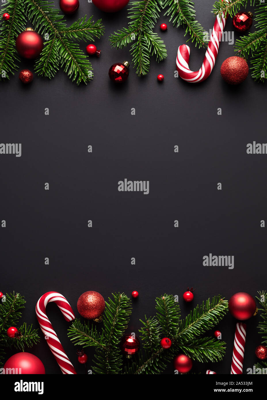 Nero a Natale e Anno Nuovo sfondo. Cornice decorativa di rami di abete, palle di Natale e Candy canes Foto Stock
