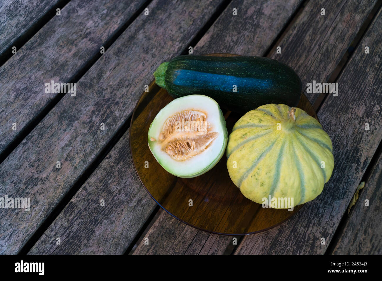 Gmo Meloni e zucchine su un tavolo di legno direttamente dall'alto Foto Stock