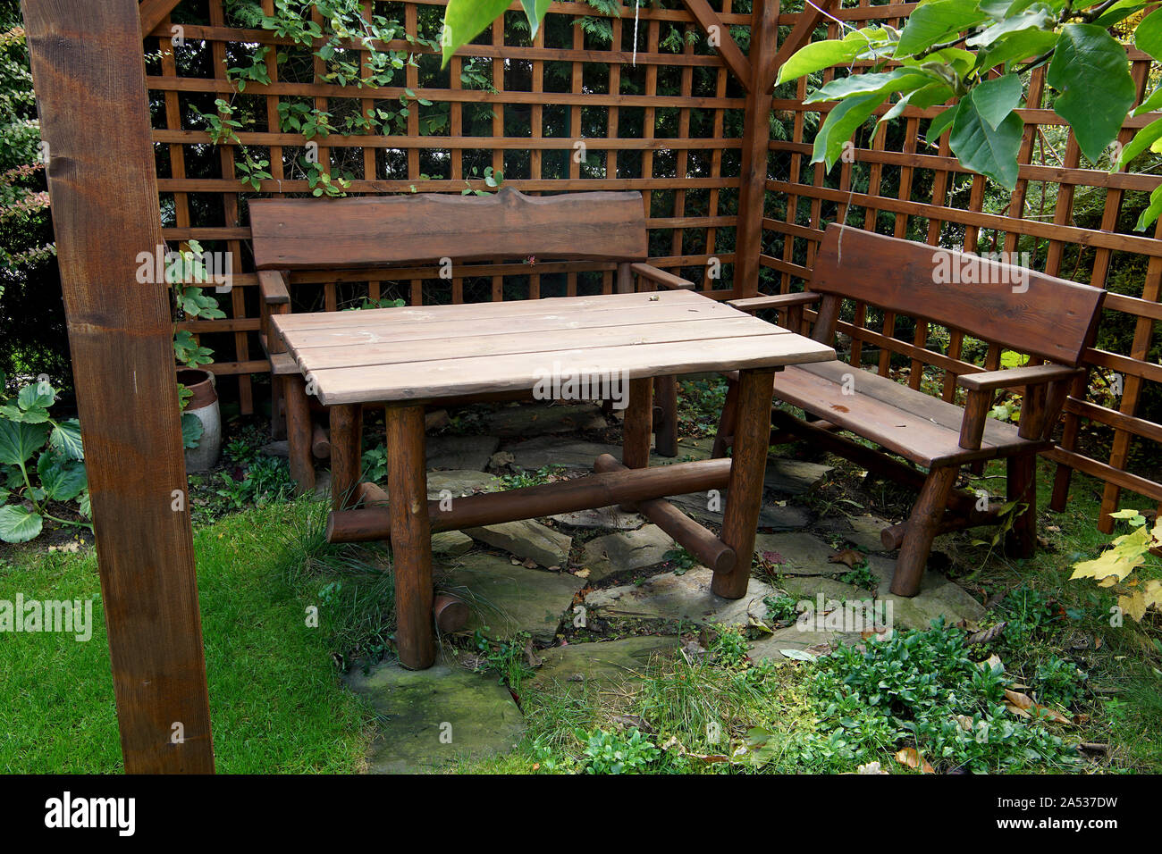 Mobili da giardino in legno in piedi nel gazebo con pareti ventilate Foto Stock