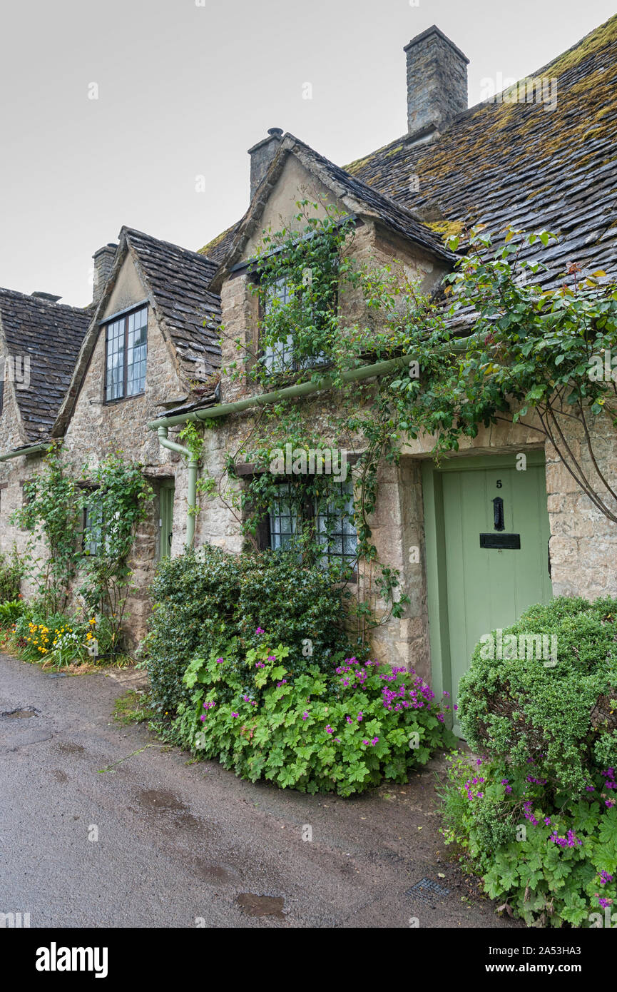 Tradizionale cotswold cottage in pietra costruito di distintivo giallo calcare nella famosa in tutto il mondo, Arlington Row, Bibury, Gloucestershire, Inghilterra Foto Stock