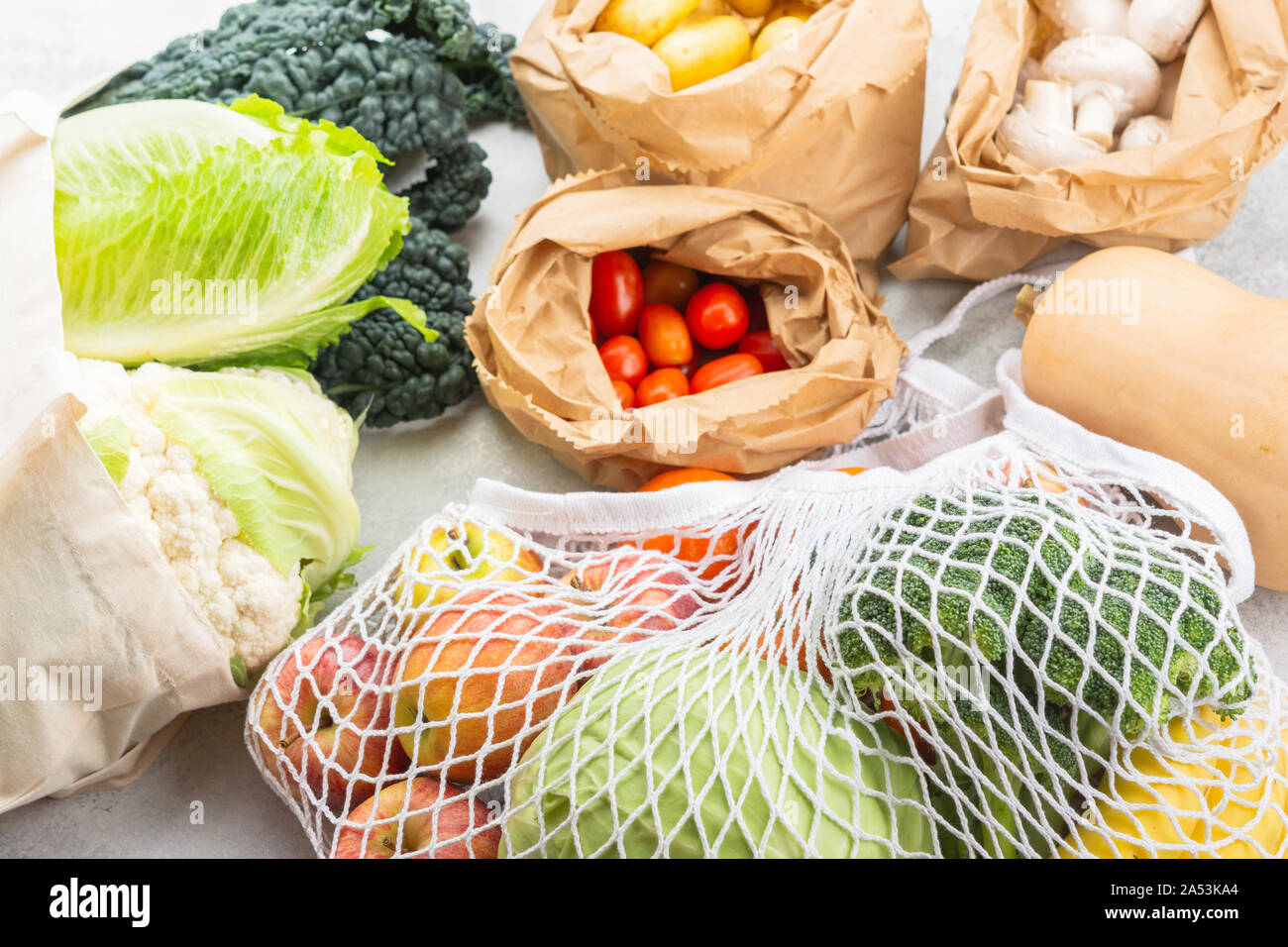 Rifiuti Zero eco friendly shopping concetto, frutta verdura in maglia bianca di cotone e sacchi di carta bianca sul tavolo da cucina, il fuoco selettivo Foto Stock