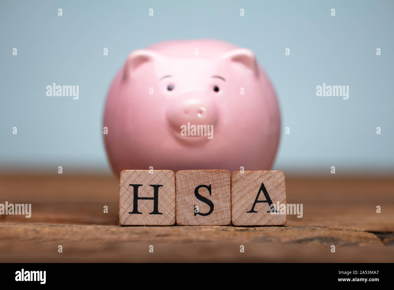 Il sistema HSA Health Conto di risparmio dei blocchi di legno vicino Piggybank sul tavolo Foto Stock