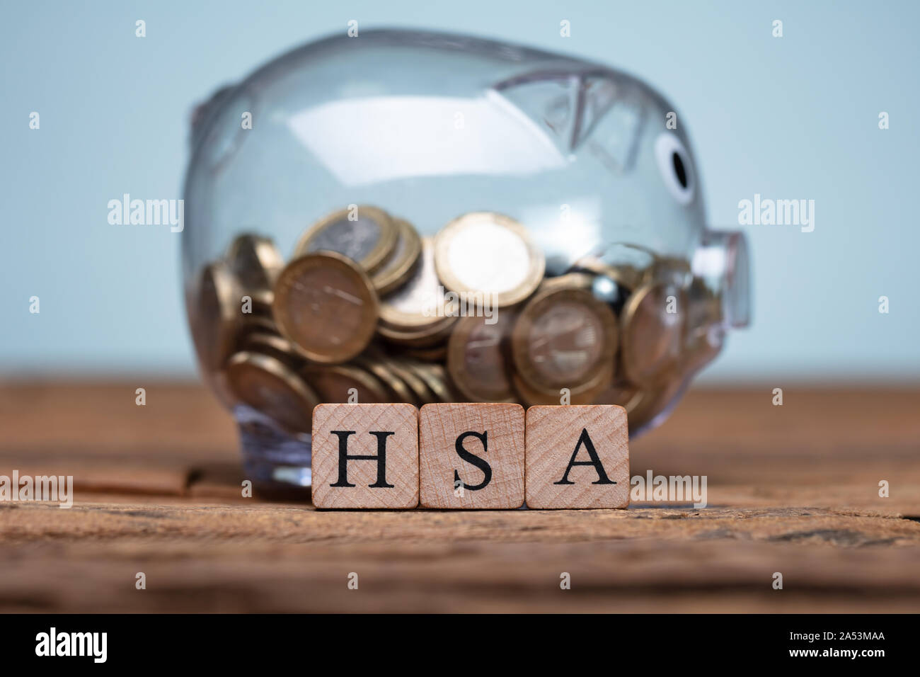 Il sistema HSA Health Conto di risparmio dei blocchi di legno vicino Piggybank sul tavolo Foto Stock