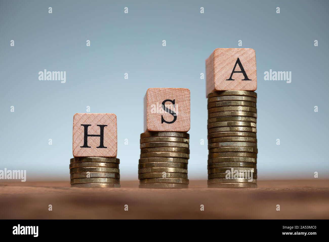 Il sistema HSA Health Conto di risparmio dei blocchi di legno su pile di monete Foto Stock