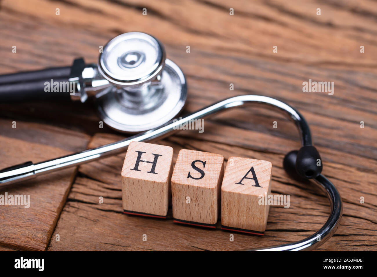 Il sistema HSA Health Conto di risparmio dei blocchi di legno vicino a uno stetoscopio sul tavolo di legno Foto Stock