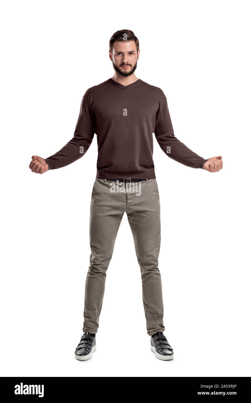 Un uomo barbuto in abito casual stand con le sue braccia ha tenuto fuori ampia con le dita in stretto i pugni in una vista frontale. Foto Stock
