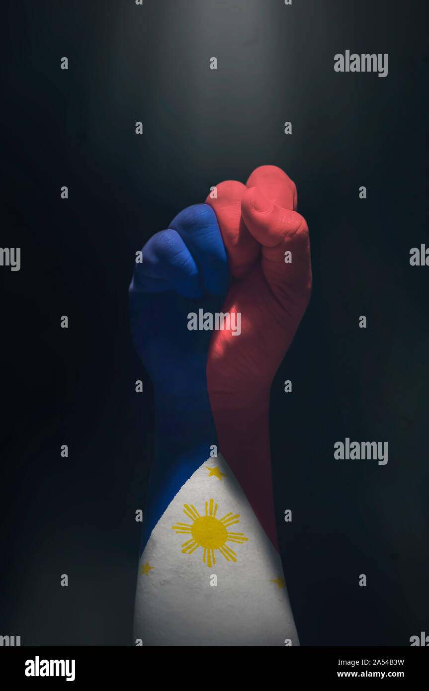 Pugno chiuso di una Bandiera delle Filippine. Mano filippino che mostra un simbolo di forte e indipendenza. Chiudere la presa dipinte a mano in un filippino bandiera. Foto Stock