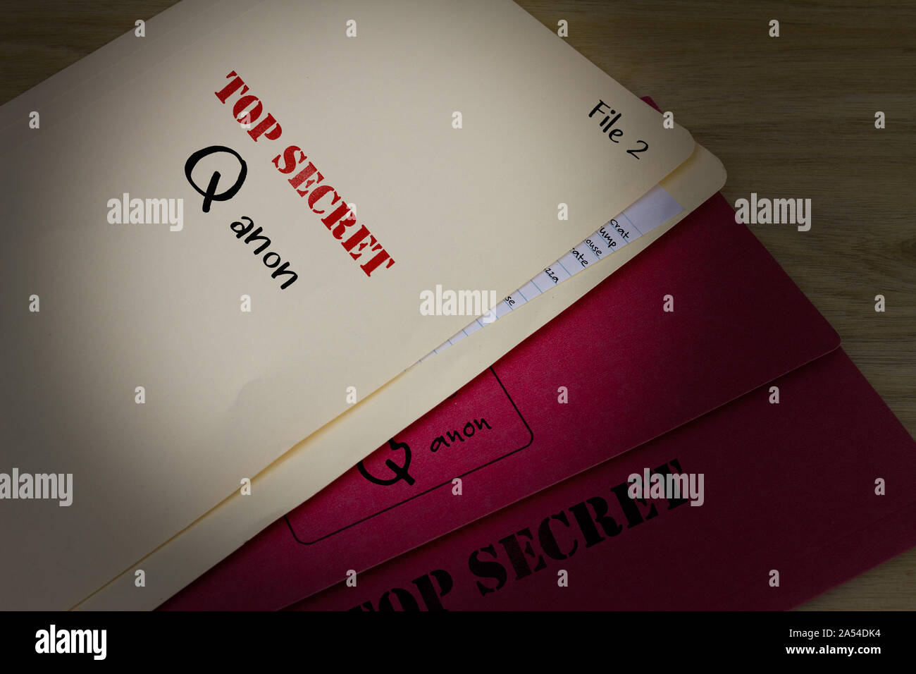 Top Secret Q anon file in torcia luce sulla scrivania, conservatore americano profondo stato teoria della cospirazione Concetto di immagine. Foto Stock