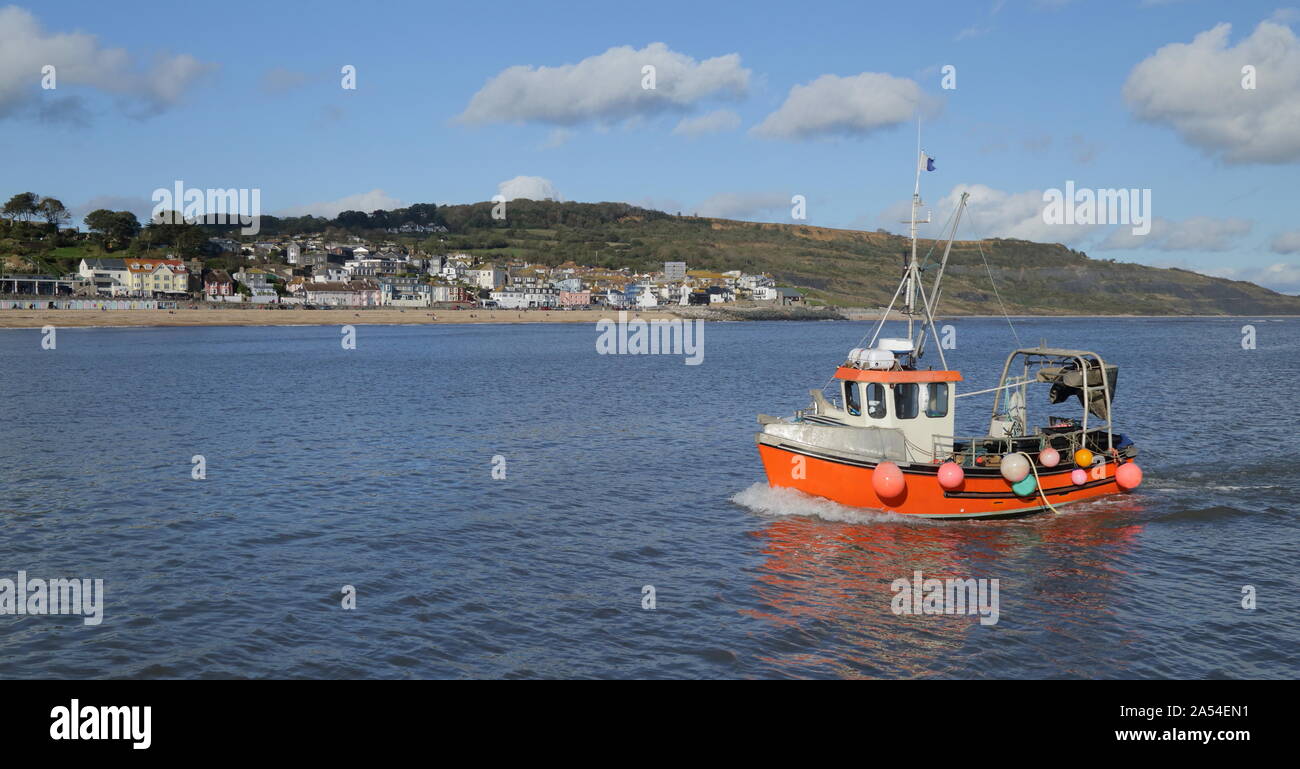 Rosso barca da pesca vicino alla città di Lyme Regis in Dorset Foto Stock
