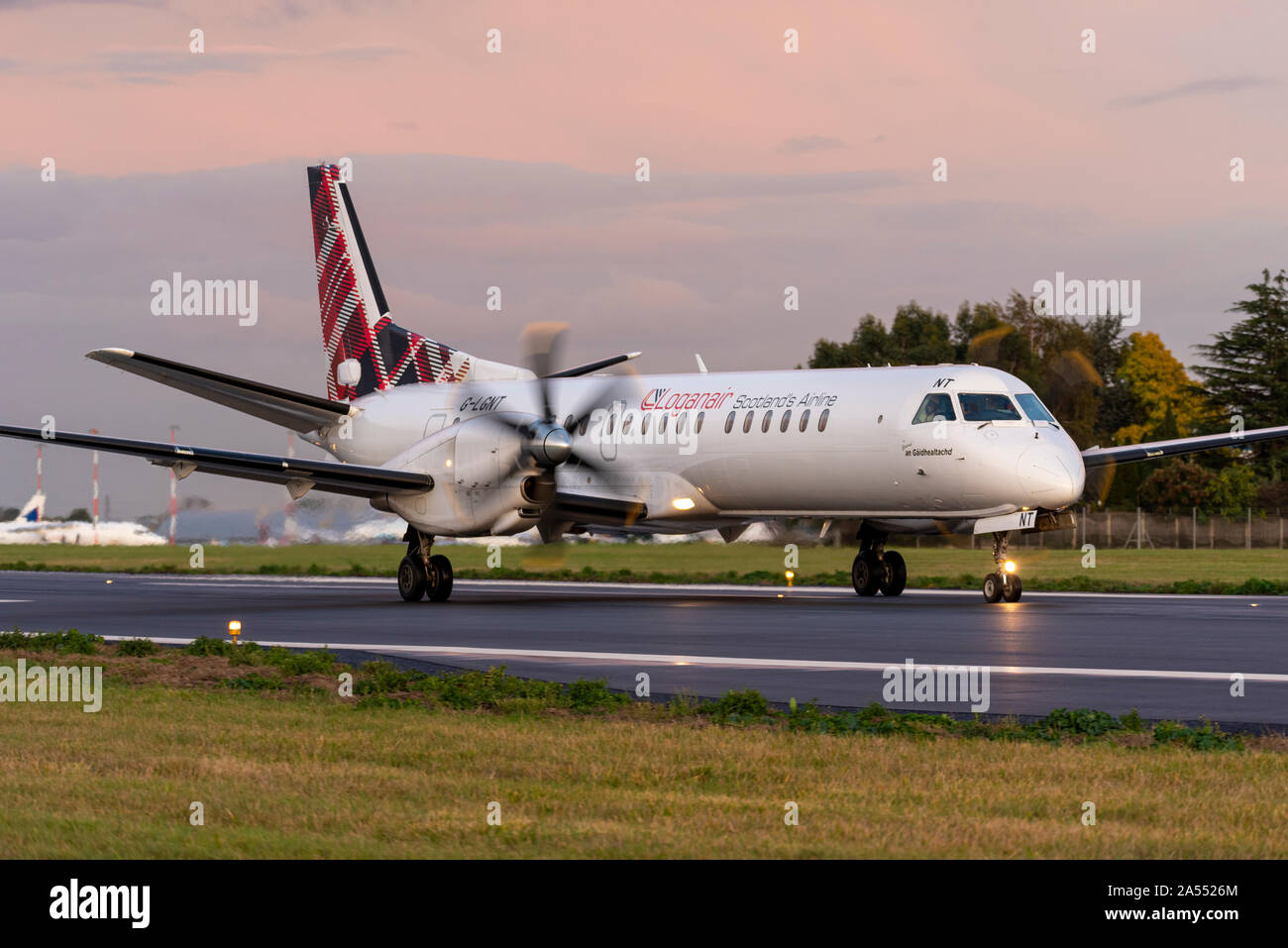 Loganair Saab 2000 turboelica aereo di linea rullante dopo l'atterraggio all'aeroporto di Londra Southend, Southend on Sea, Essex UK su una pista umida Foto Stock